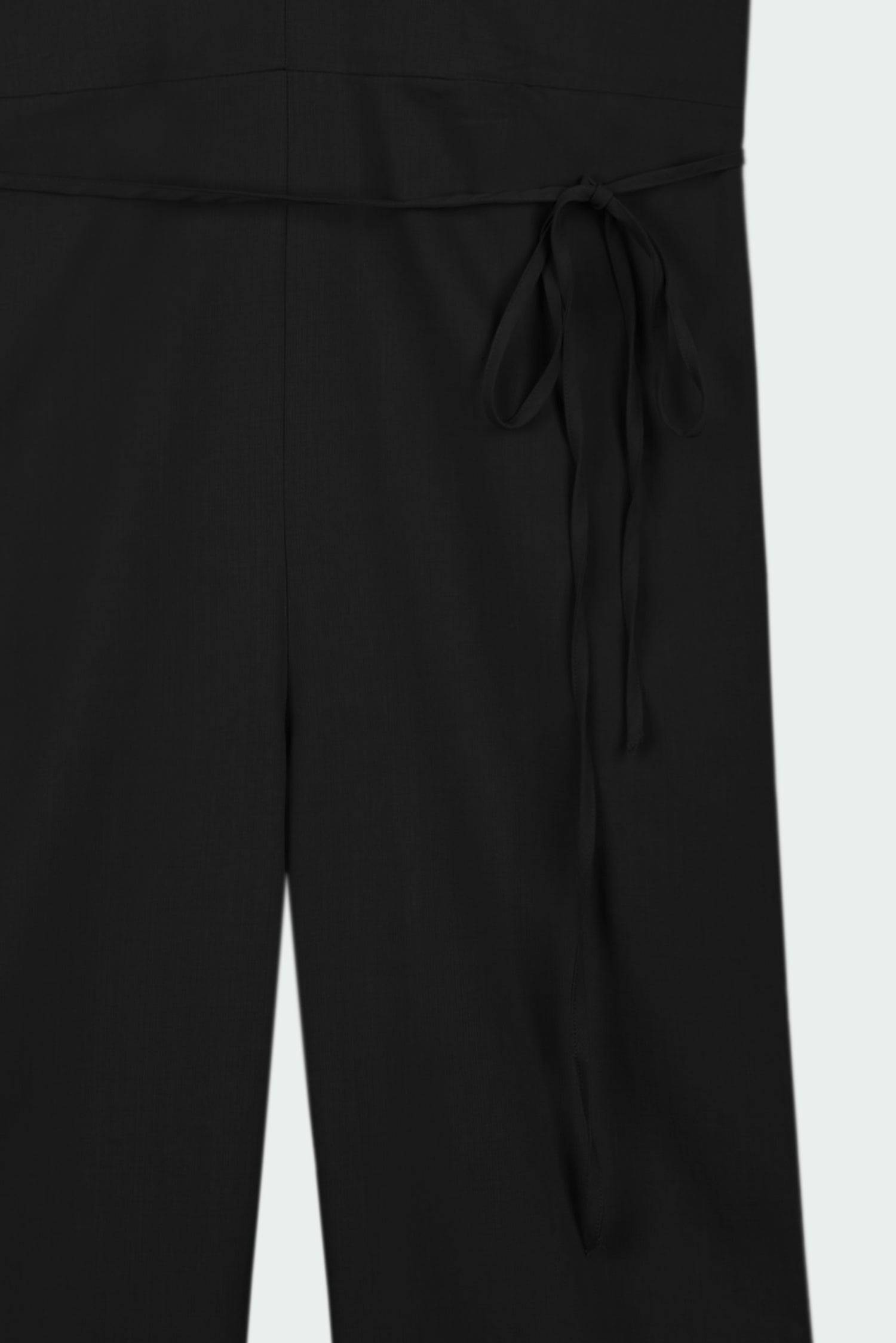 Daisy Jumpsuit in black, sleeveless linen blend jumpsuit with adjustable halterneck, open back, straight-leg silhouette, and relaxed fit.