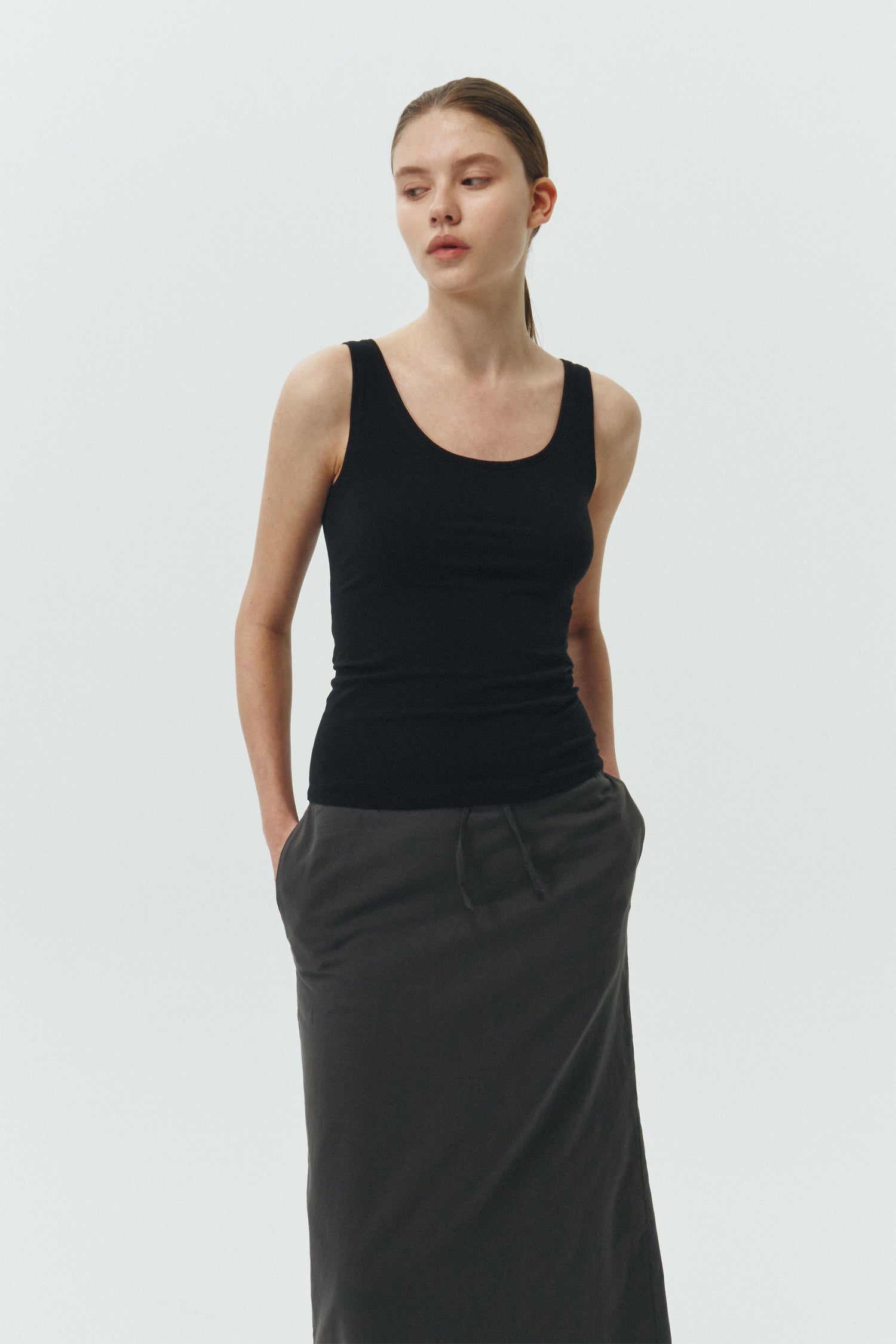 Zoe Tank Top in black, slim-fit stretch cotton tank with scooped neckline and diagonal seam detail for a sleek and minimal silhouette.