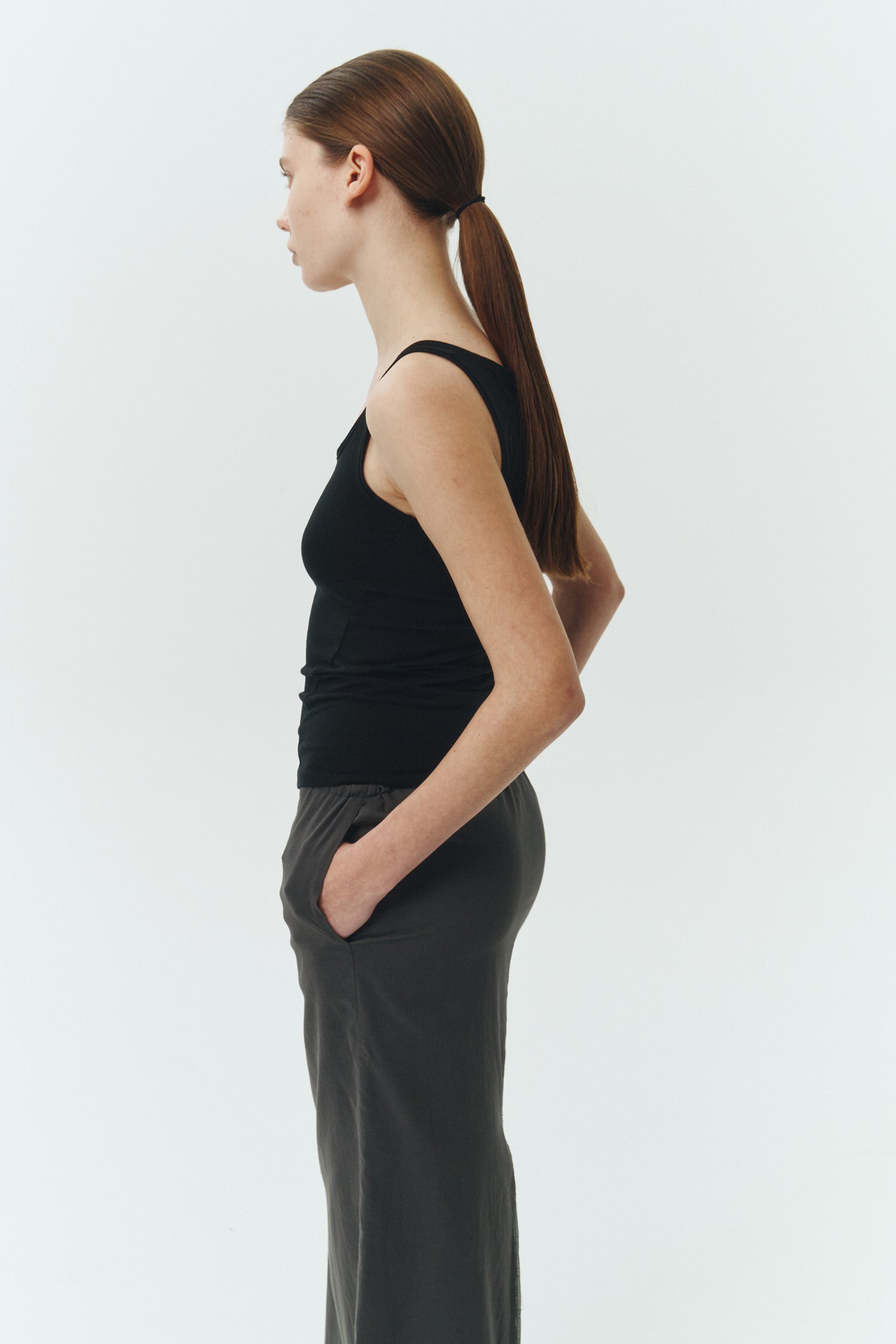 Amelia Skirt in charcoal, a lightweight cotton midi skirt with inner drawstring waist, hidden side pockets, lined layers, raw-edge hem, and a center back slit for ease and movement