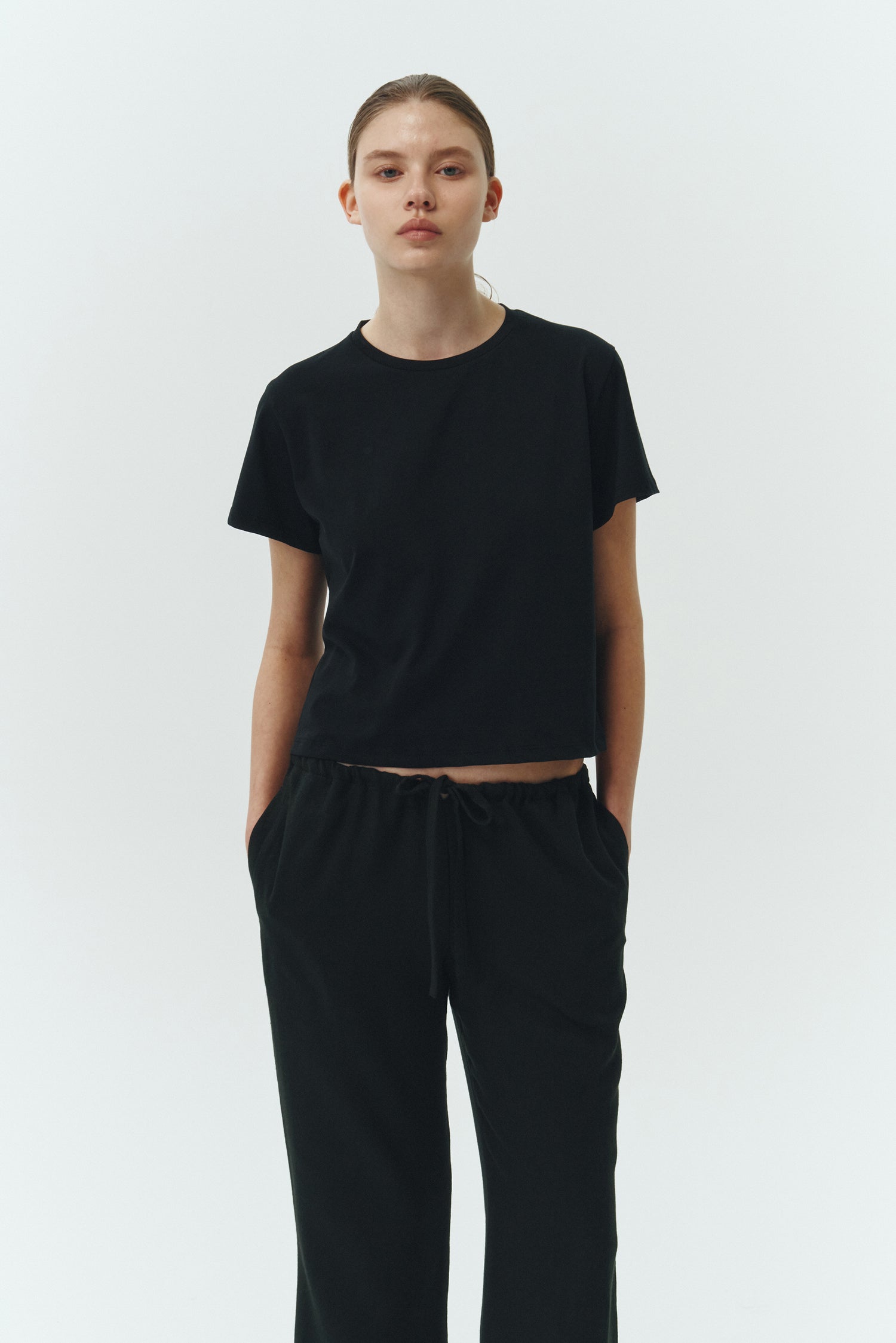 Chloe Pants in black, lightweight cotton pants with a drawstring waist, side pockets, and a flared bottom, relaxed fit for effortless everyday wear