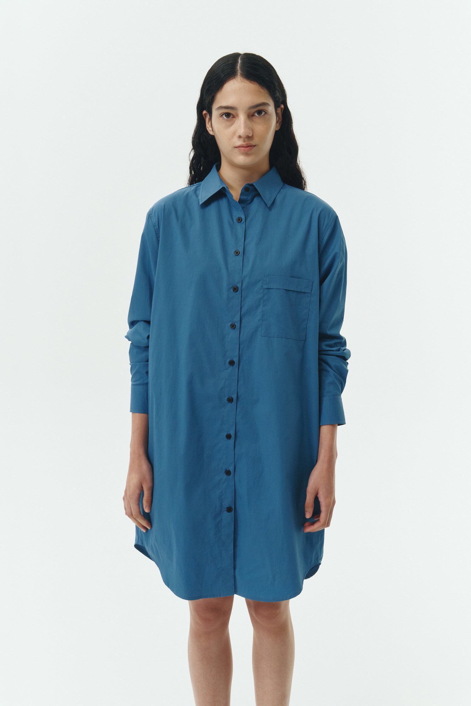 Cara Dress in blue green, long sleeve cotton shirt dress with front chest pocket, curved hem, hidden side pockets, and a relaxed silhouette.