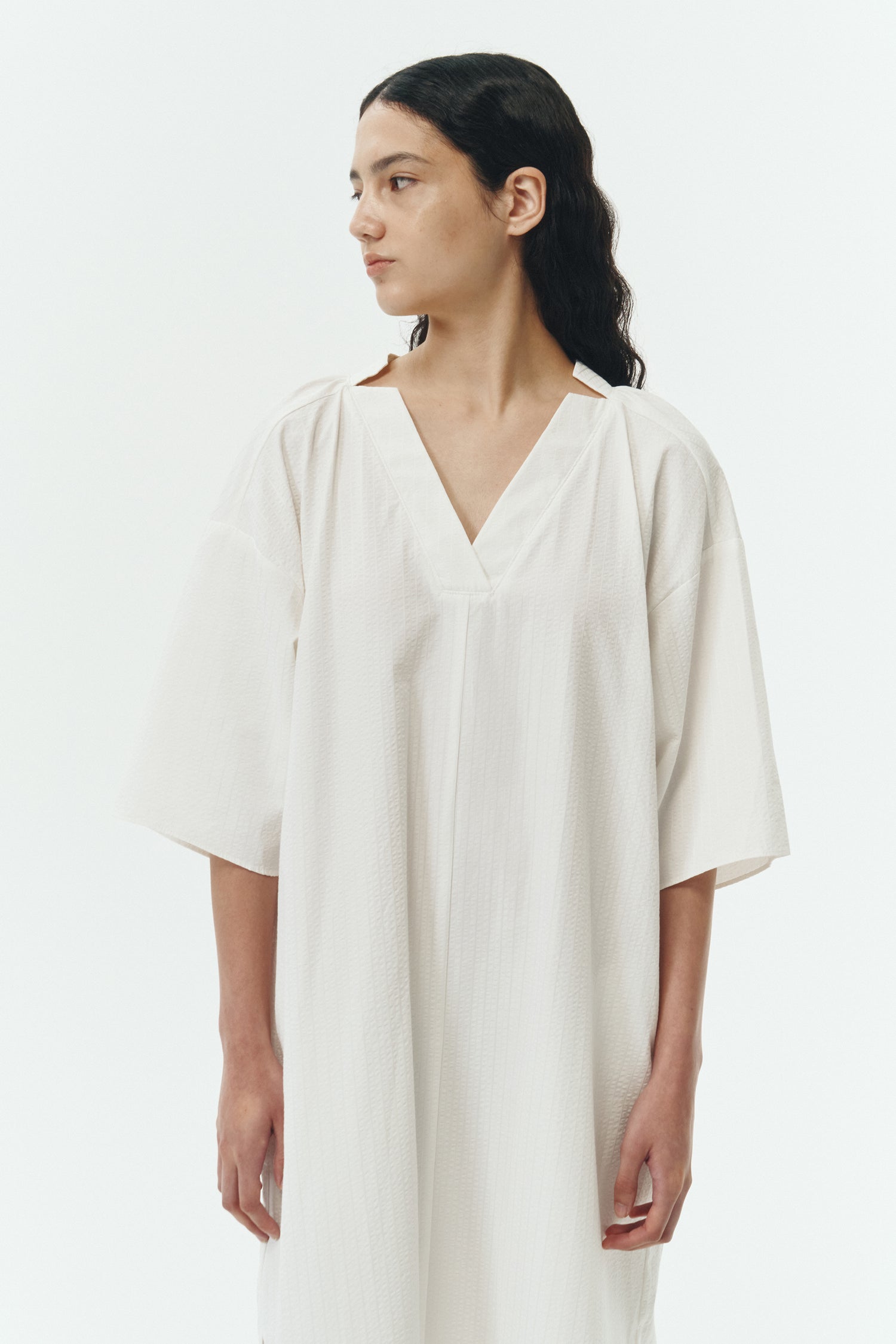 Charlotte Dress in white stripe, V-neck summer maxi dress in a lightweight linen-rayon blend with drop shoulders, hidden side pockets, raw edge hem, and a relaxed fit.
