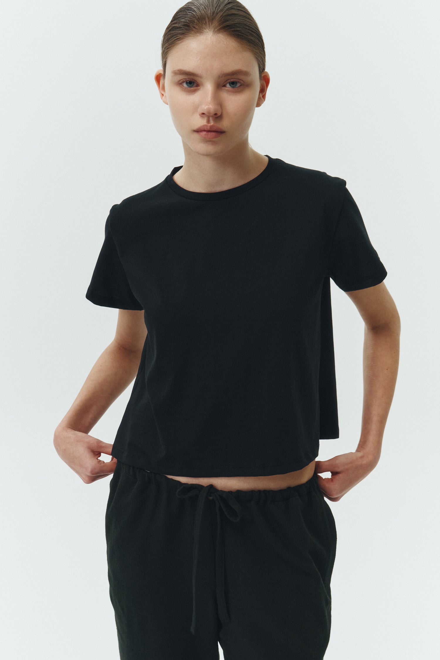 Ivy T-shirt in black, cropped short-sleeve tee in a lightweight cotton-poly blend with crew neck, regular fit, and clean silhouette.