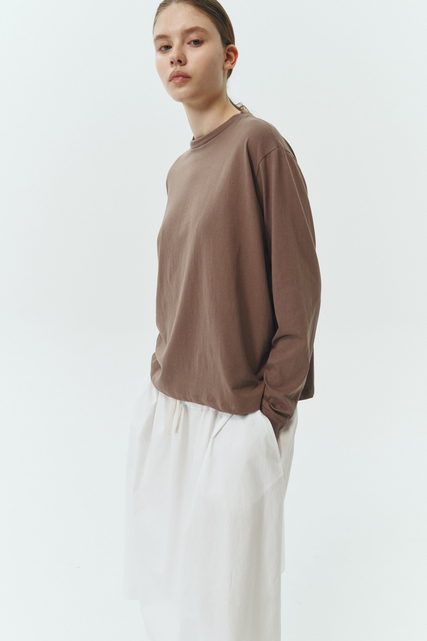Lara Long-Sleeved T-Shirt in brown, a lightweight cotton crew-neck tee with long sleeves and relaxed fit, ideal for everyday wear and seasonal layering