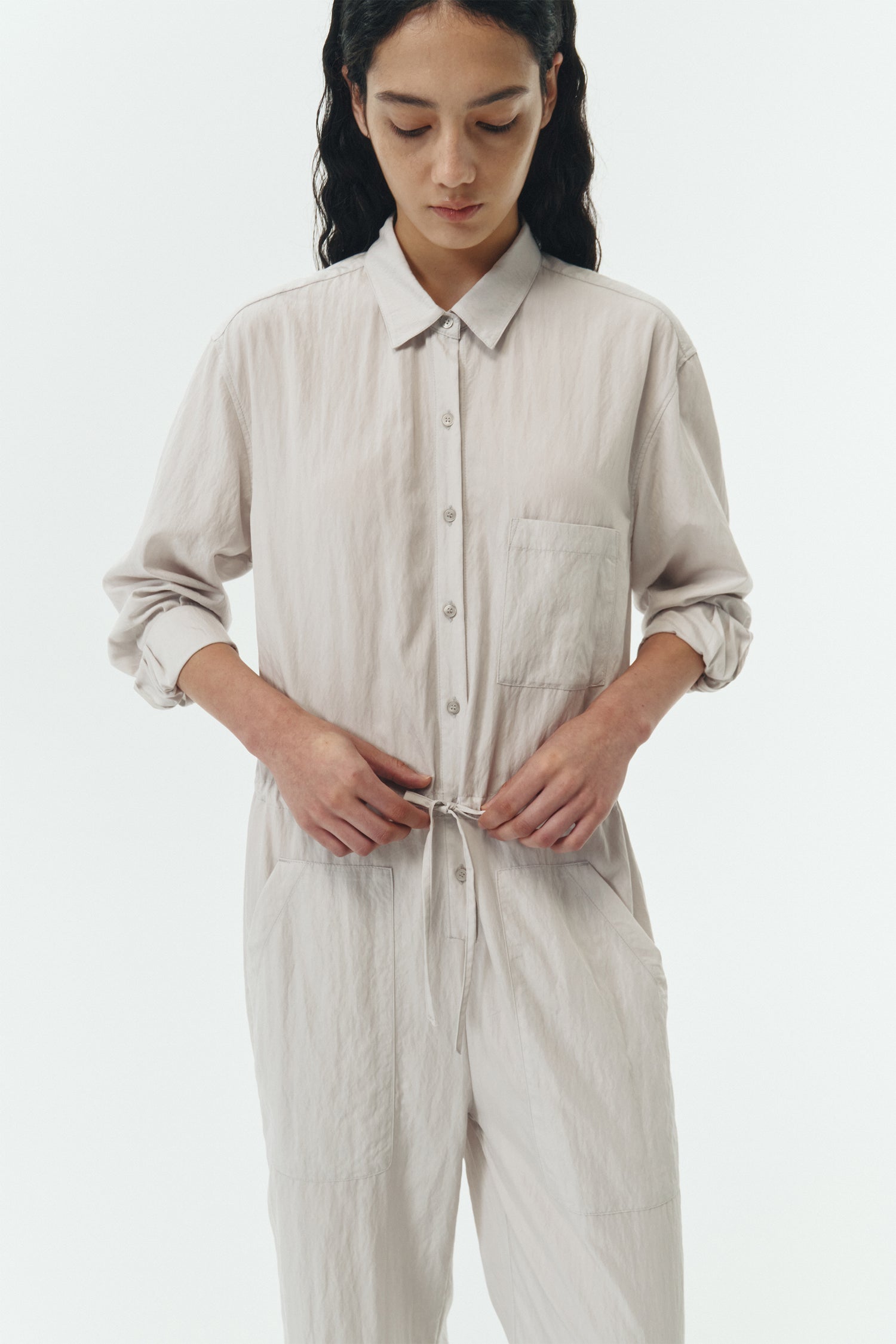 Saige Jumpsuit in cloud, long-sleeve rayon blend jumpsuit with point collar, front button closure, drawstring waist, and patch pockets.