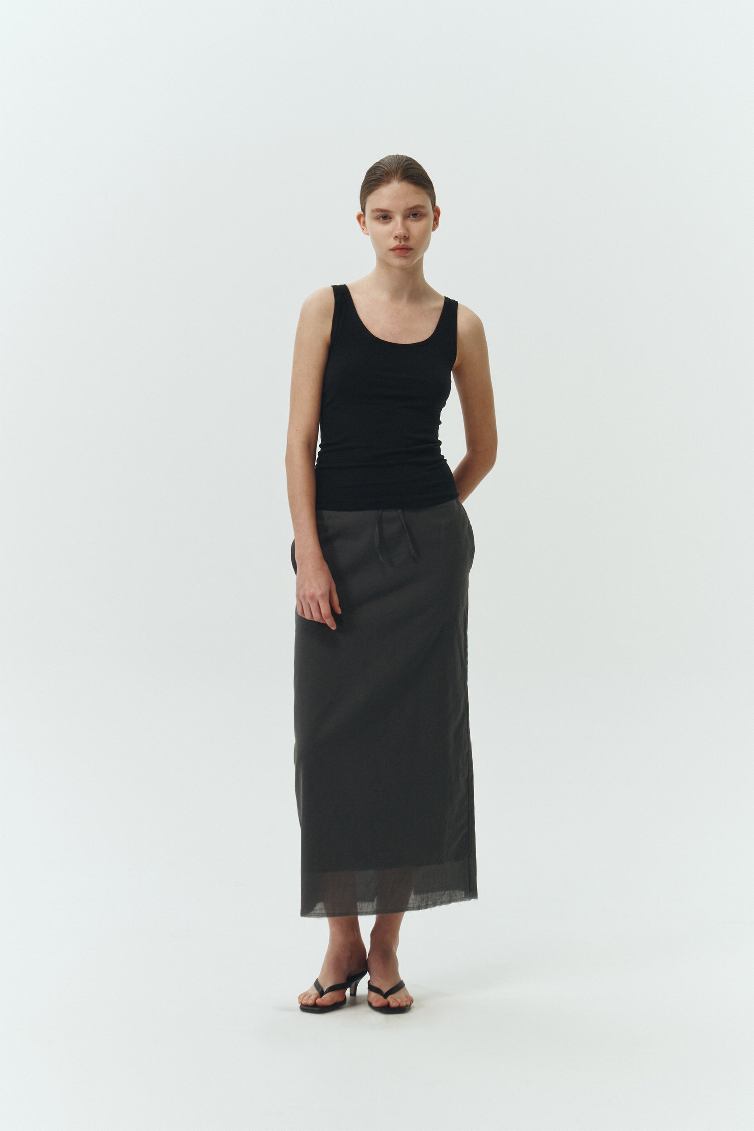 Zoe Tank Top in black, slim-fit stretch cotton tank with scooped neckline and diagonal seam detail for a sleek and minimal silhouette.