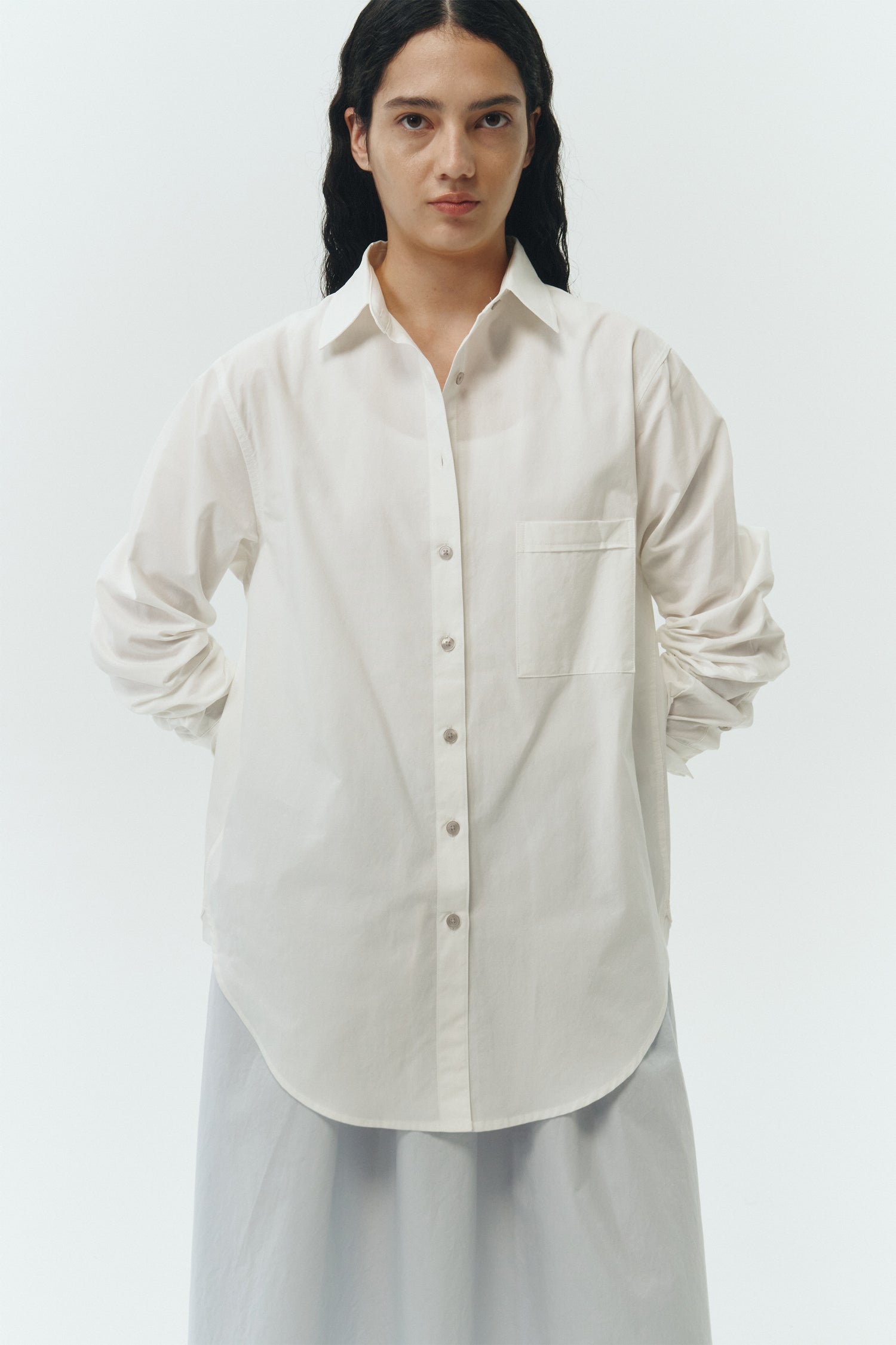 Isabella Shirt in white, a lightweight cotton-poly blend button-up with chest pocket, back pleat, and buttoned cuffs, designed in a regular fit with a hip-length silhouette