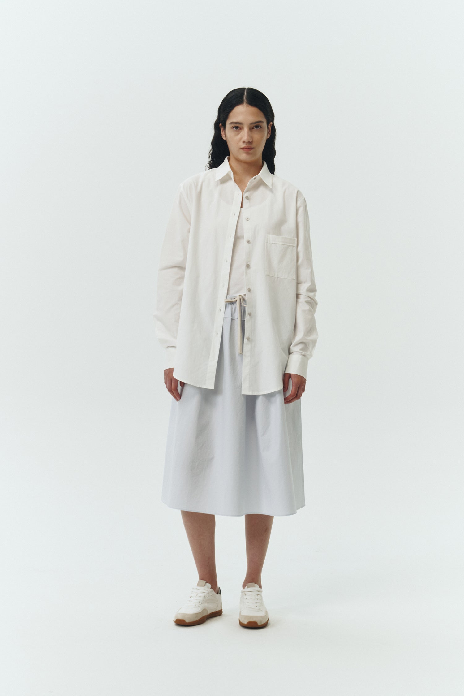 Maryam Skirt in sky, a midi cotton skirt with shirred waistband, drawstring detail, side pockets, and a softly flared silhouette