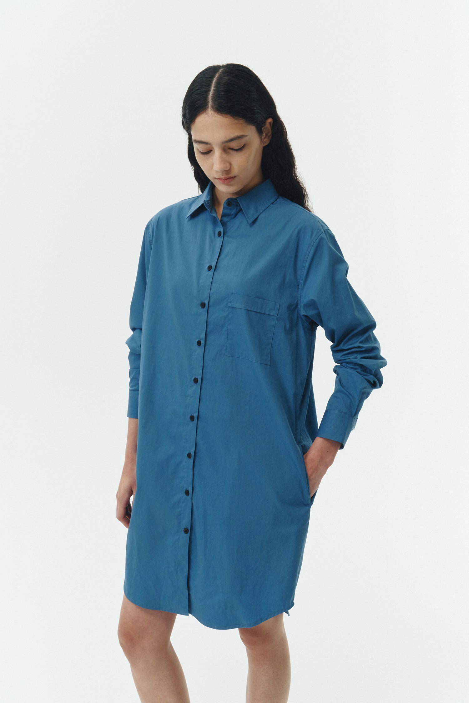 Cara Dress in blue green, long sleeve cotton shirt dress with front chest pocket, curved hem, hidden side pockets, and a relaxed silhouette.