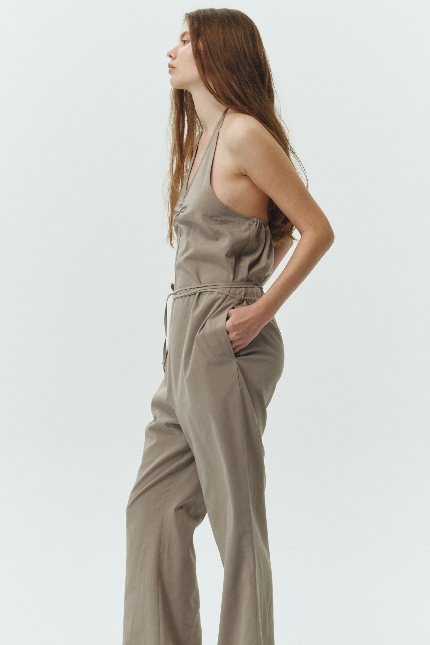 Daisy Jumpsuit in khaki gray, sleeveless linen blend jumpsuit with adjustable halterneck, open back, straight-leg silhouette, and relaxed fit.