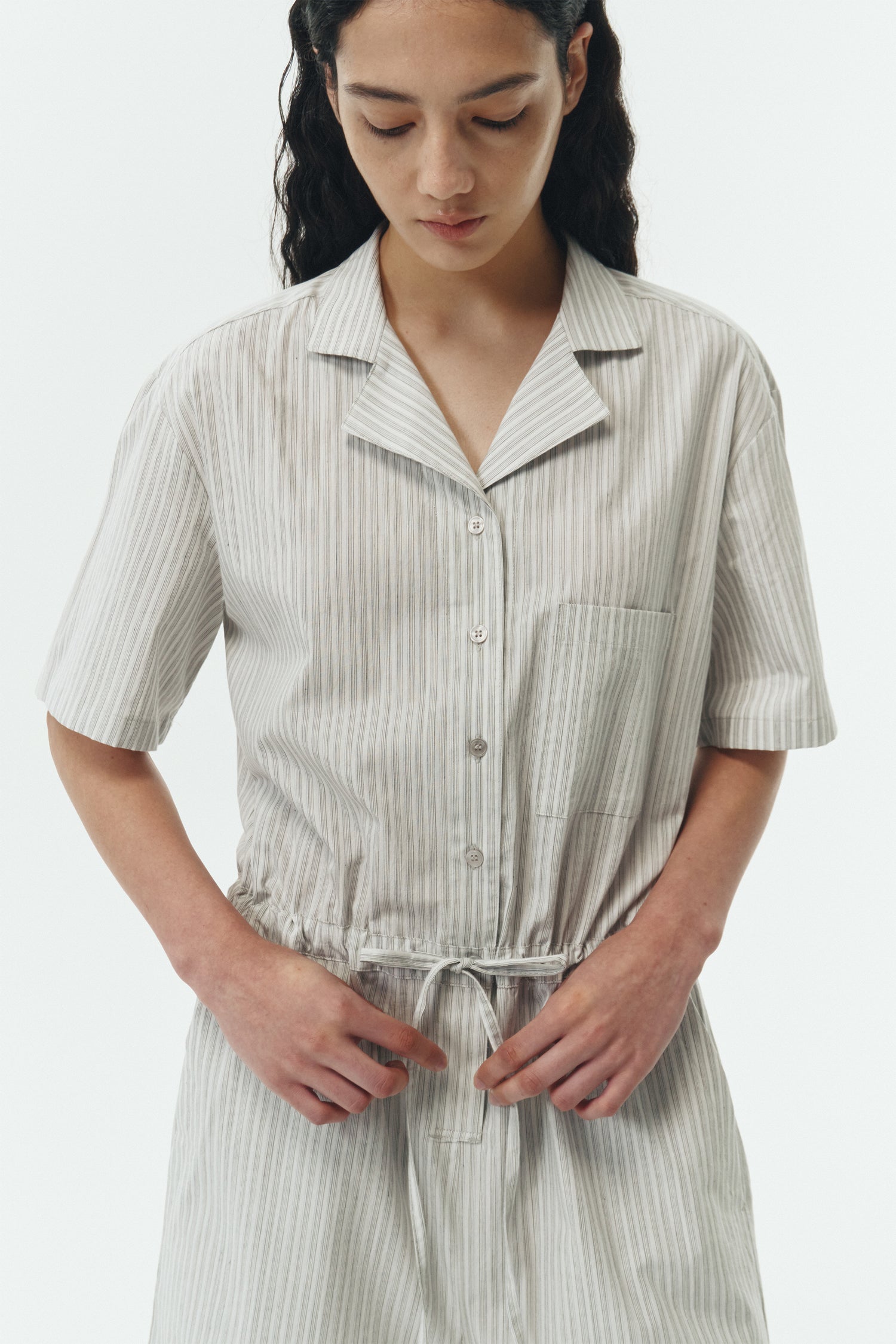 Emma Jumpsuit in stripe, short-sleeve cotton jumpsuit with camp collar, front buttons, drawstring waist, and multiple pockets.