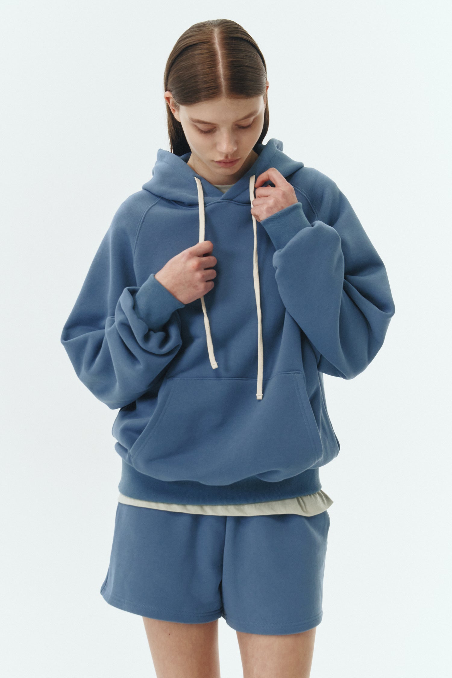 Kaia Hoodie in indigo blue, oversized cotton French terry pullover with drawstring hood, raglan sleeves, kangaroo pocket, and ribbed trims.