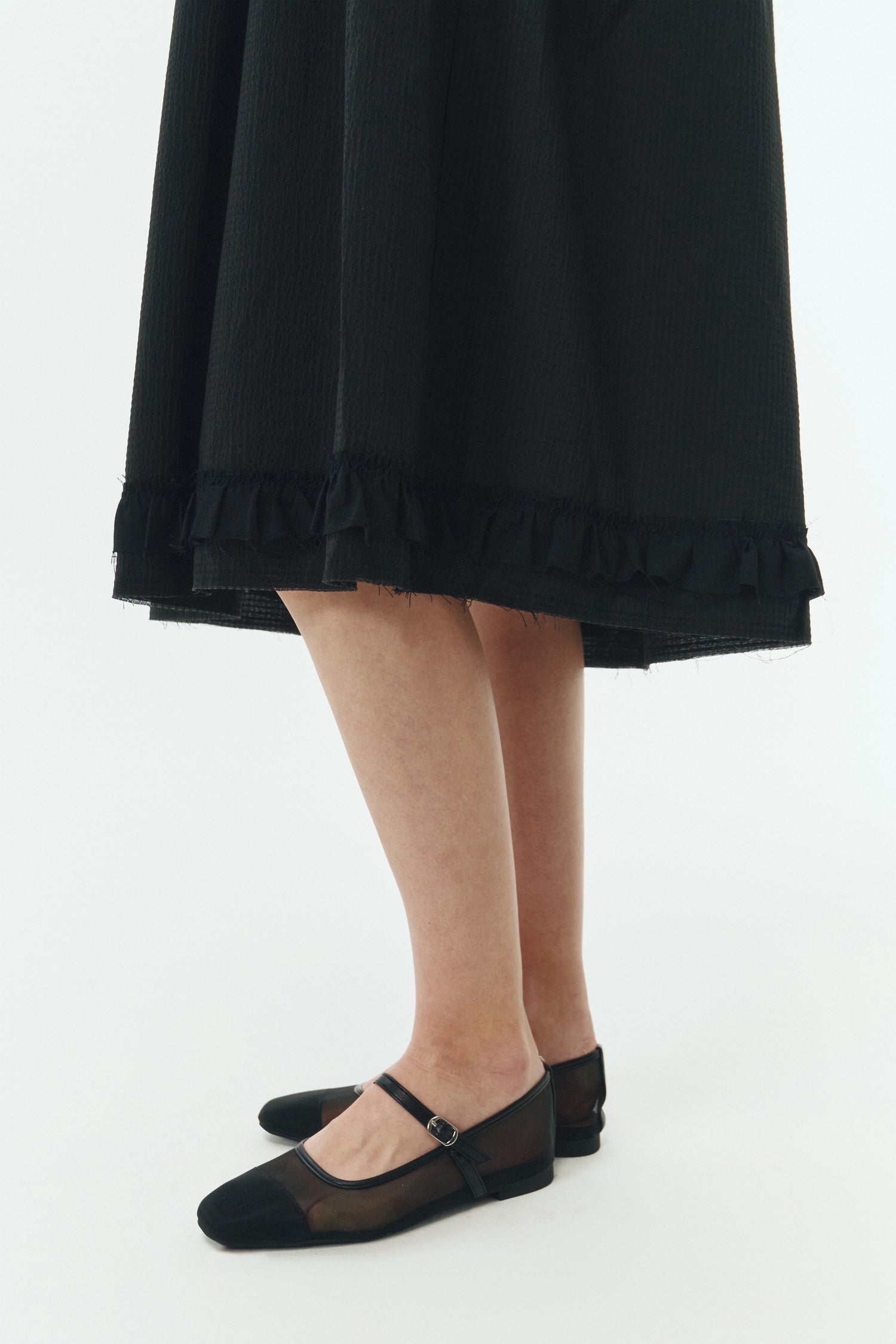 Pina Dress in black, sleeveless cotton midi dress with shirring at waist and hem, hidden side pockets, and an open back with button closure.