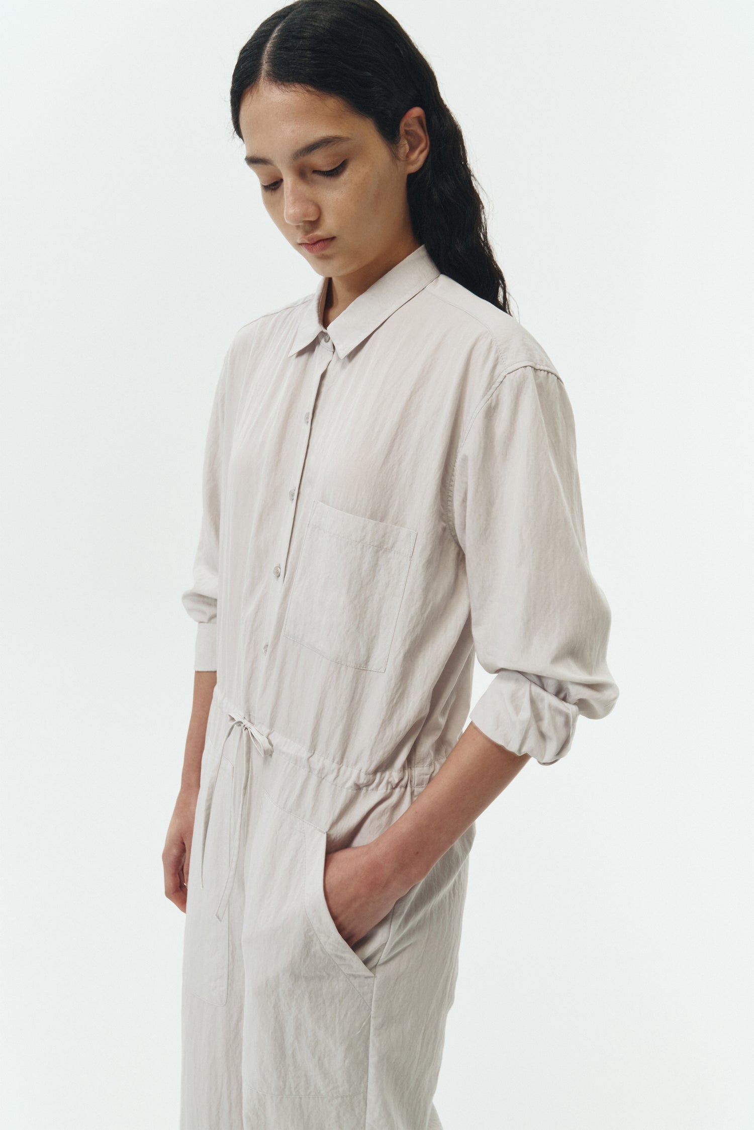 Saige Jumpsuit in cloud, long-sleeve rayon blend jumpsuit with point collar, front button closure, drawstring waist, and patch pockets.