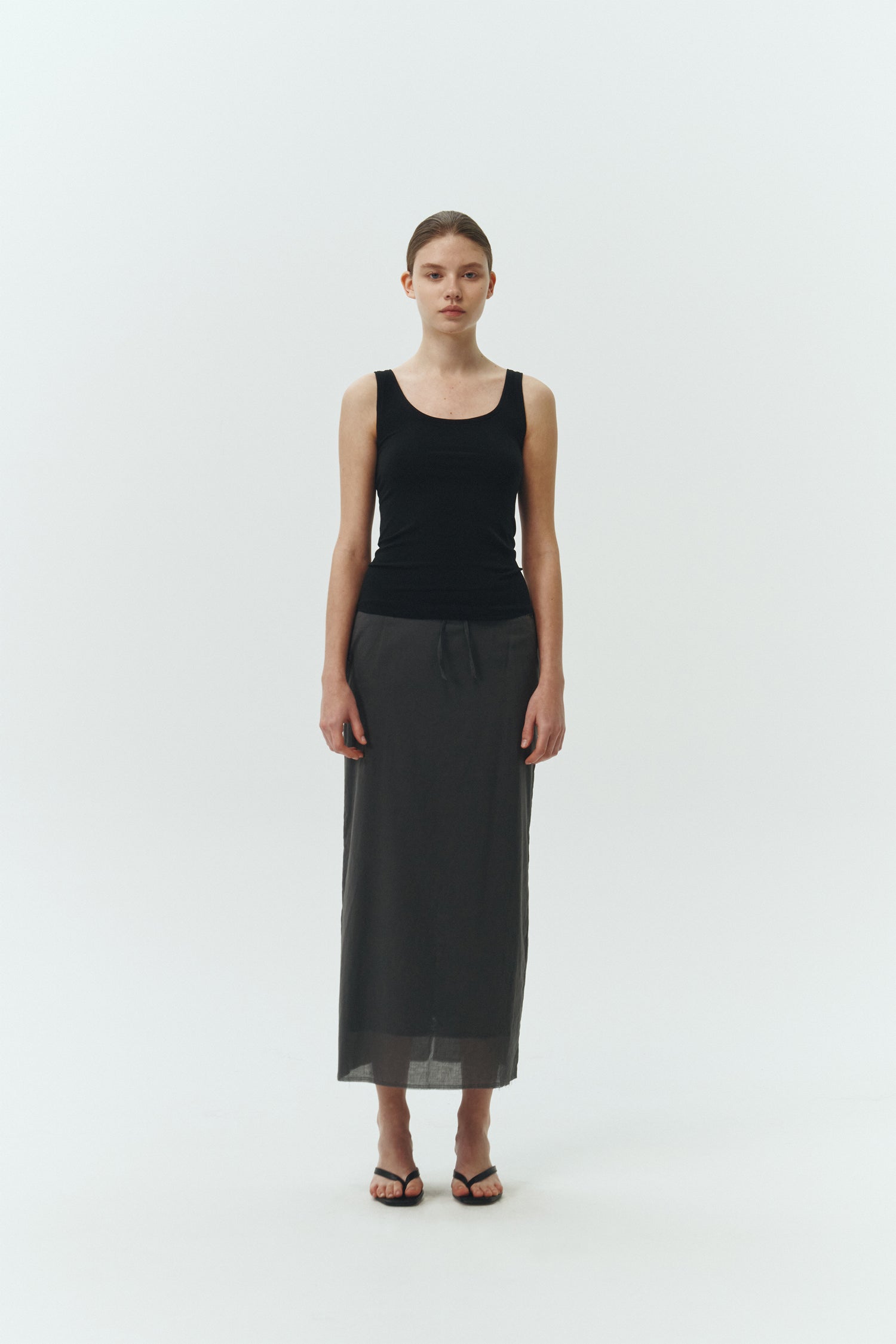 Zoe Tank Top in black, slim-fit stretch cotton tank with scooped neckline and diagonal seam detail for a sleek and minimal silhouette.