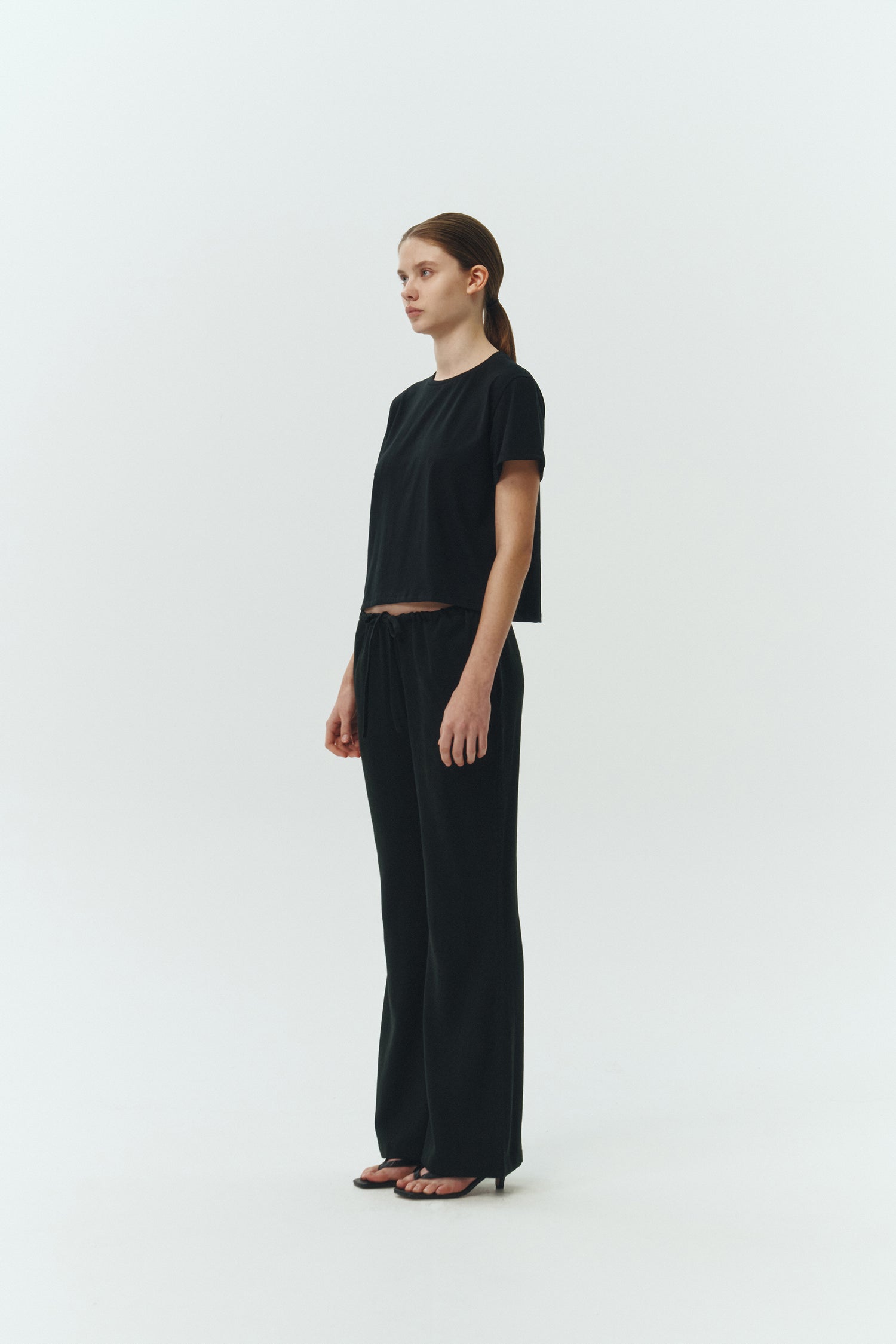 Chloe Pants in black, lightweight cotton pants with a drawstring waist, side pockets, and a flared bottom, relaxed fit for effortless everyday wear