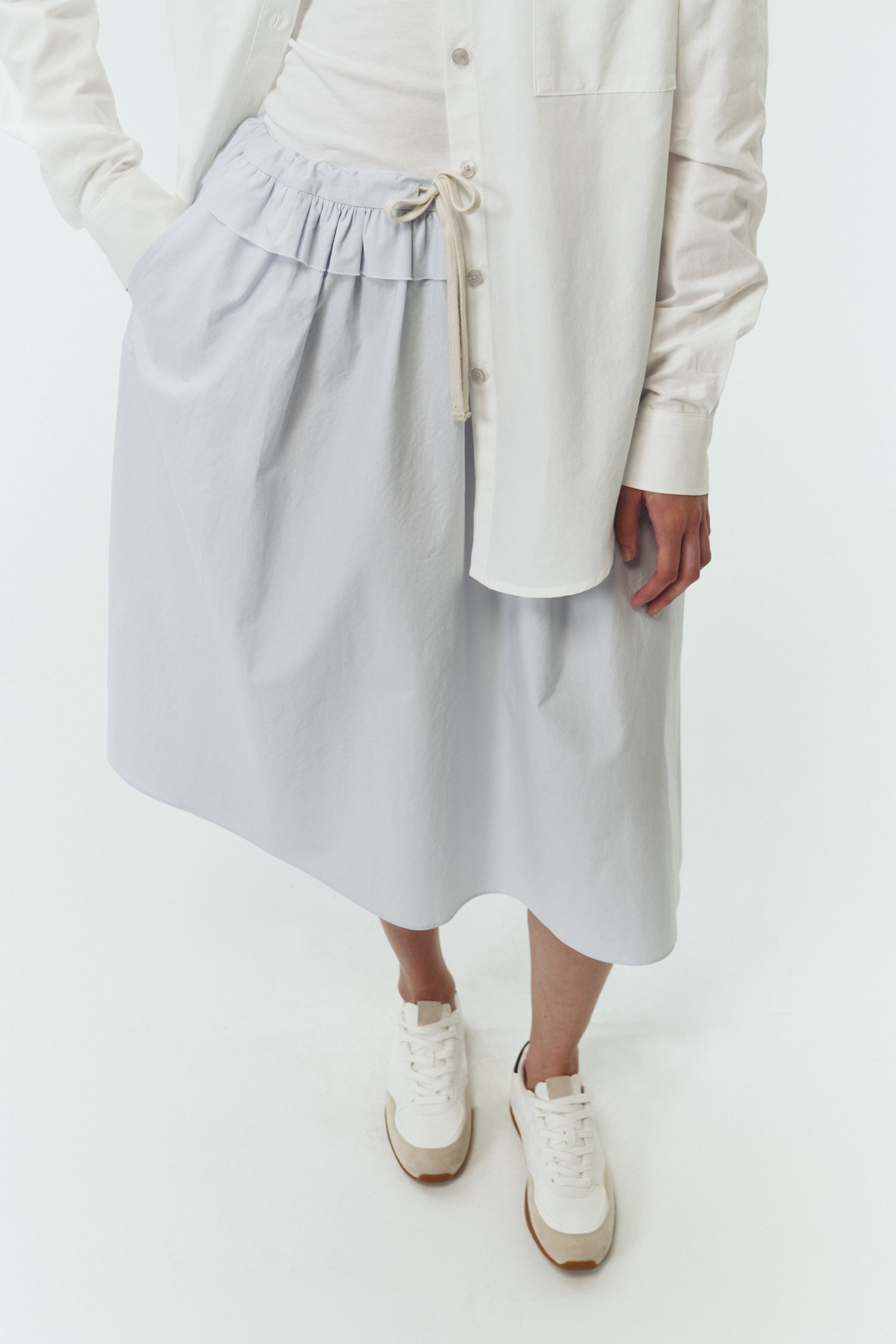 Maryam Skirt in sky, a midi cotton skirt with shirred waistband, drawstring detail, side pockets, and a softly flared silhouette