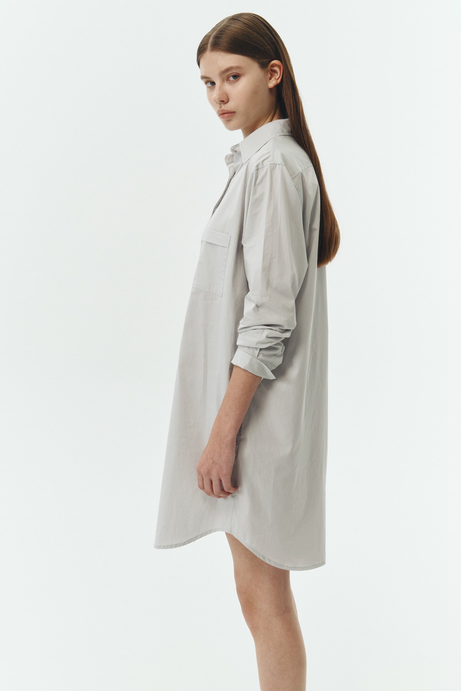 Cara Dress in cloud gray, long sleeve cotton shirt dress with front chest pocket, curved hem, hidden side pockets, and a relaxed silhouette.