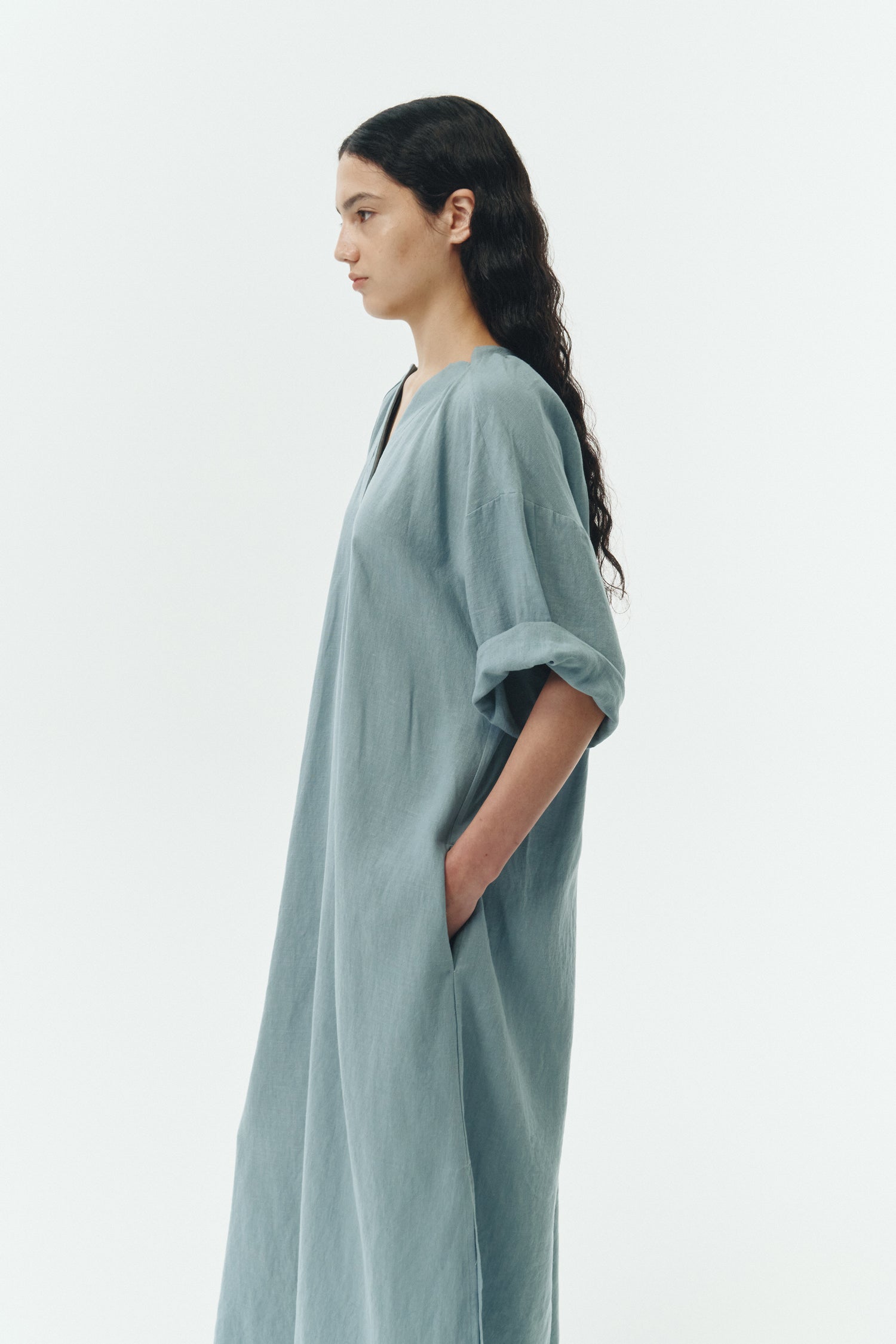 Charlotte Dress in light blue, V-neck summer maxi dress in a lightweight linen-rayon blend with drop shoulders, hidden side pockets, raw edge hem, and a relaxed fit.