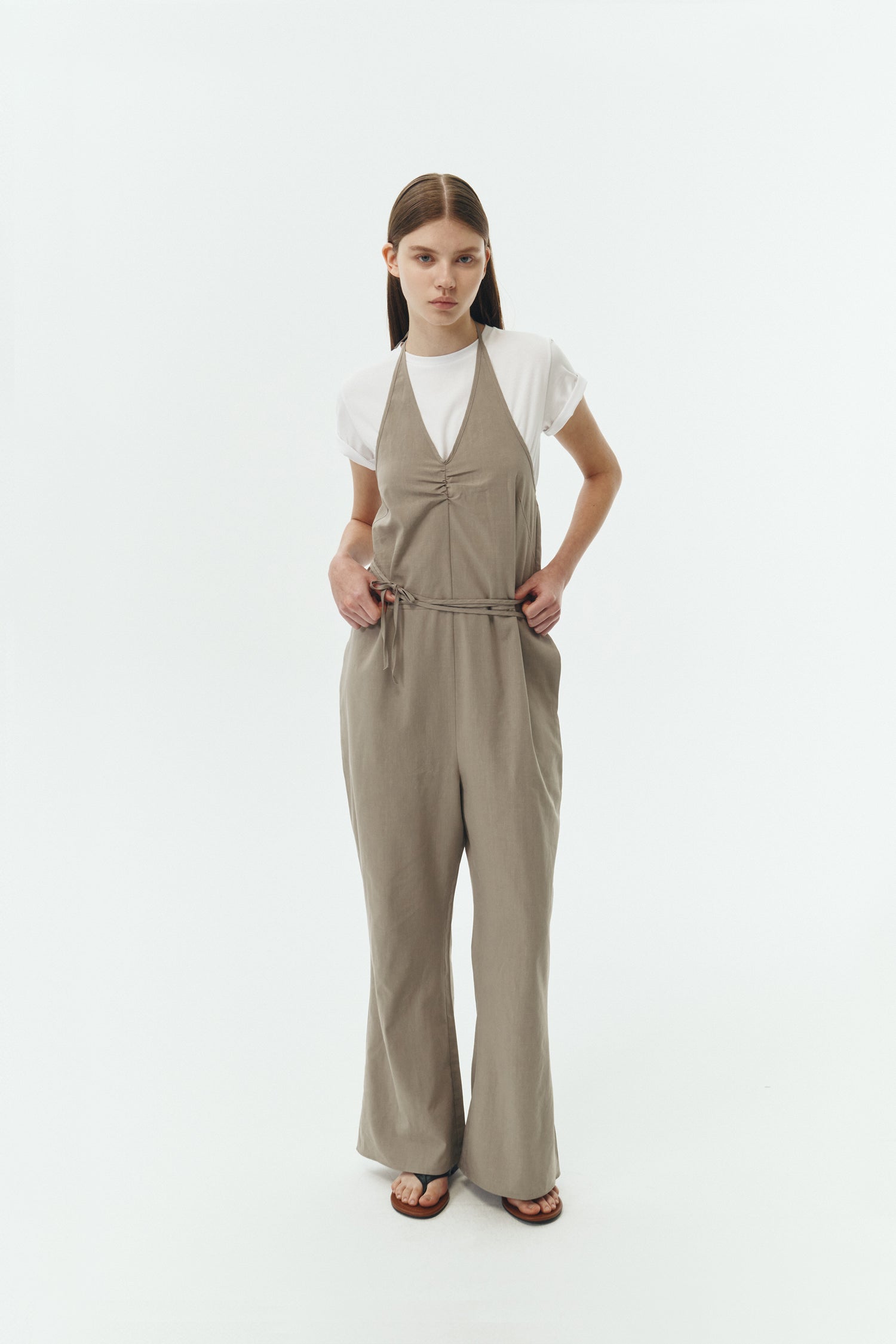Daisy Jumpsuit in khaki gray, sleeveless linen blend jumpsuit with adjustable halterneck, open back, straight-leg silhouette, and relaxed fit.