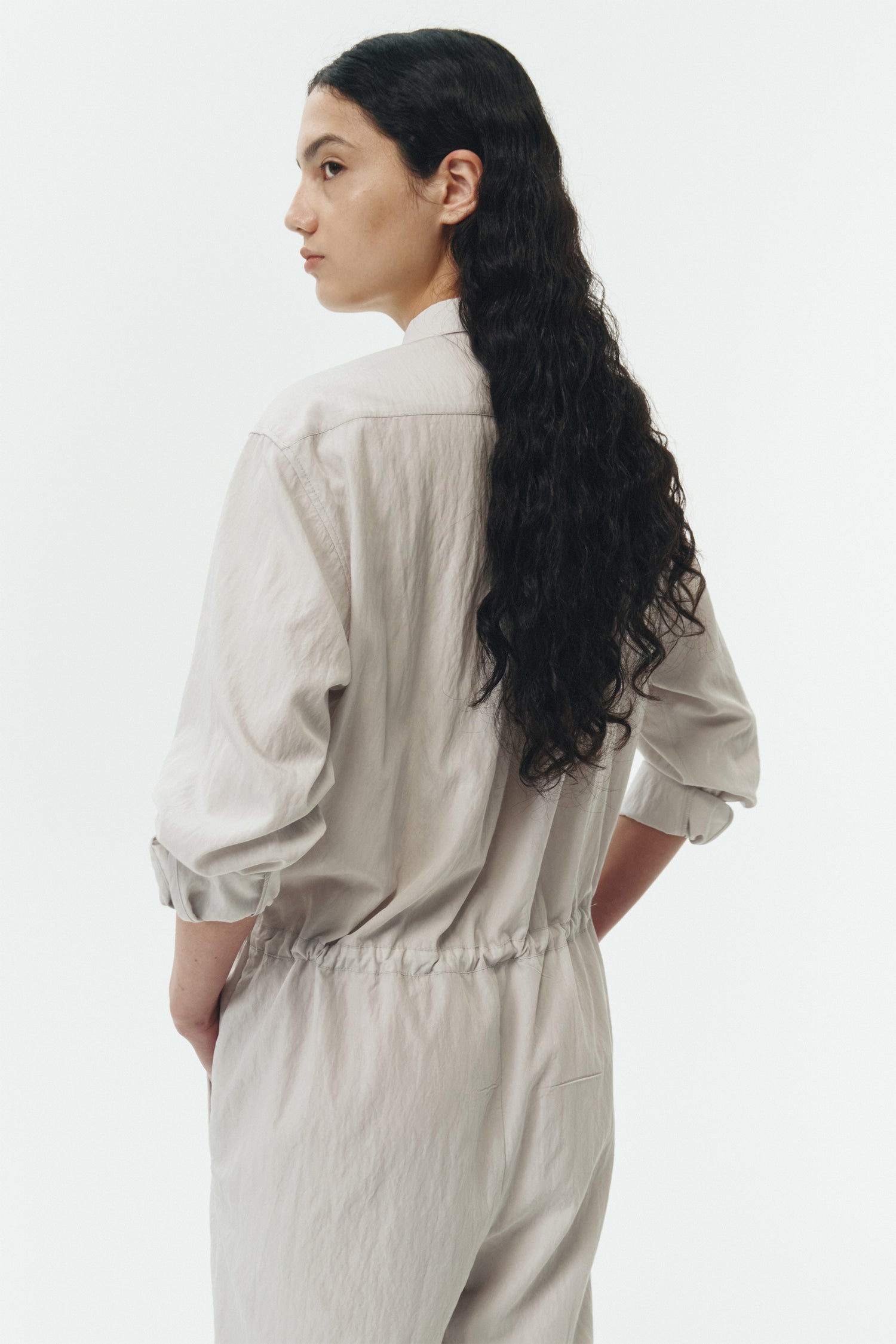 Saige Jumpsuit in cloud, long-sleeve rayon blend jumpsuit with point collar, front button closure, drawstring waist, and patch pockets.