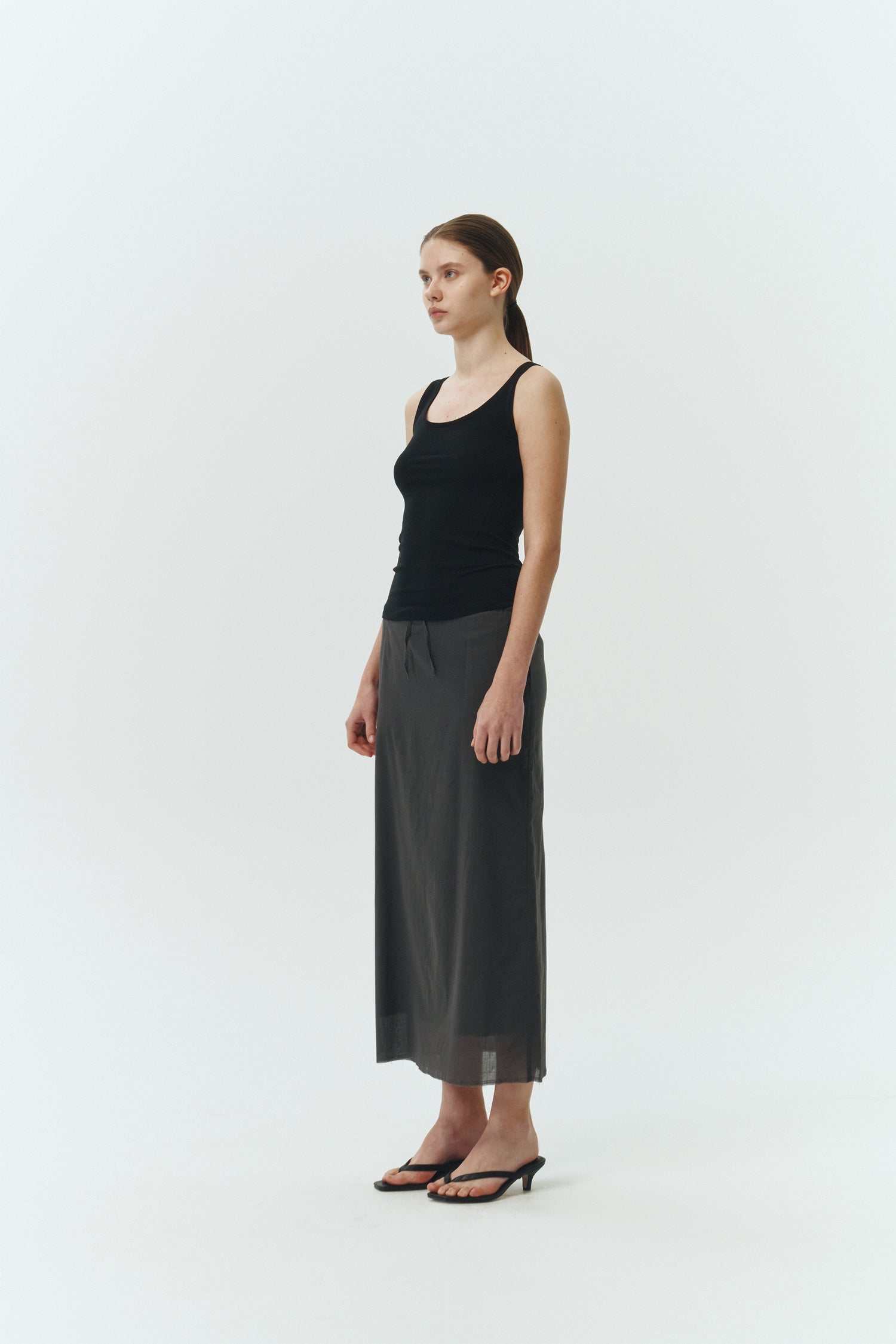 Zoe Tank Top in black, slim-fit stretch cotton tank with scooped neckline and diagonal seam detail for a sleek and minimal silhouette.