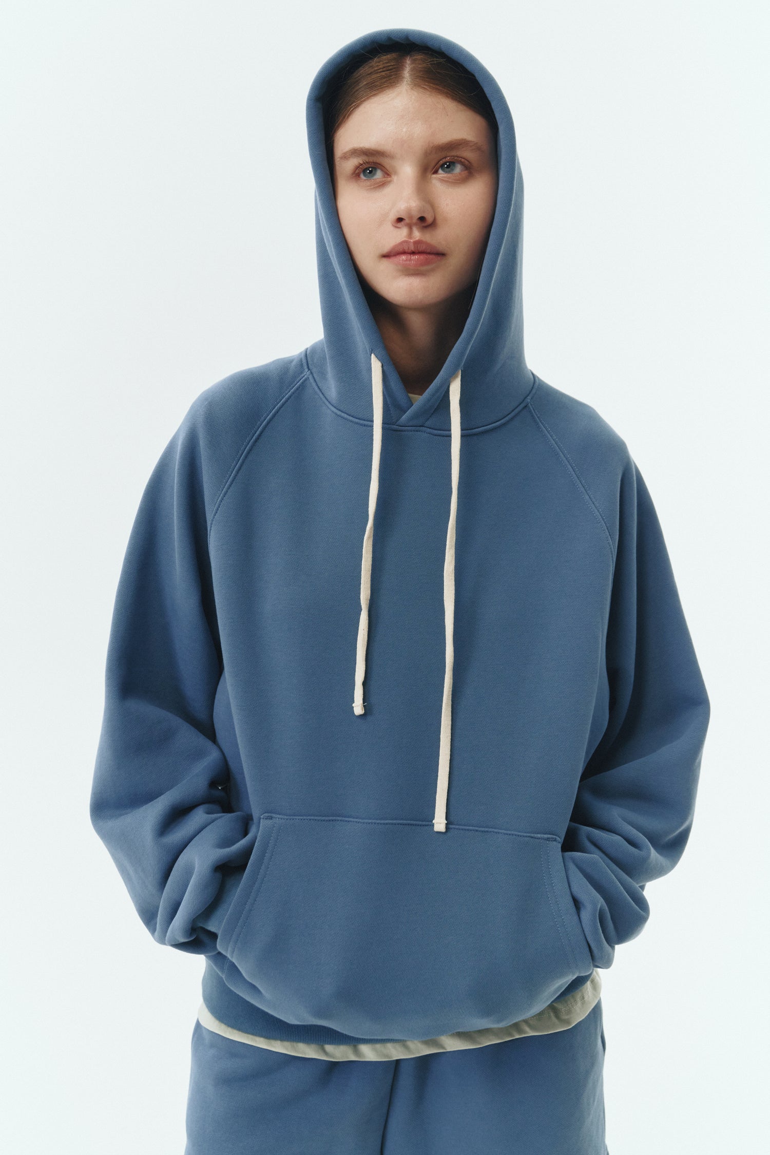 Kaia Hoodie in indigo blue, oversized cotton French terry pullover with drawstring hood, raglan sleeves, kangaroo pocket, and ribbed trims.
