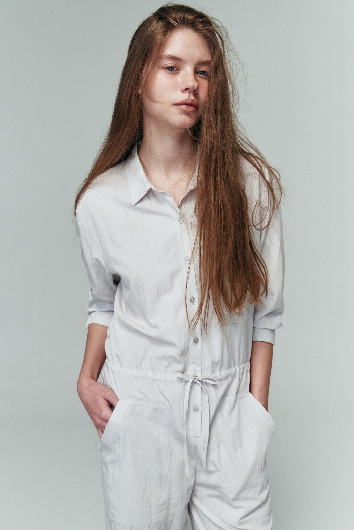 Saige Jumpsuit in cloud, long-sleeve rayon blend jumpsuit with point collar, front button closure, drawstring waist, and patch pockets.