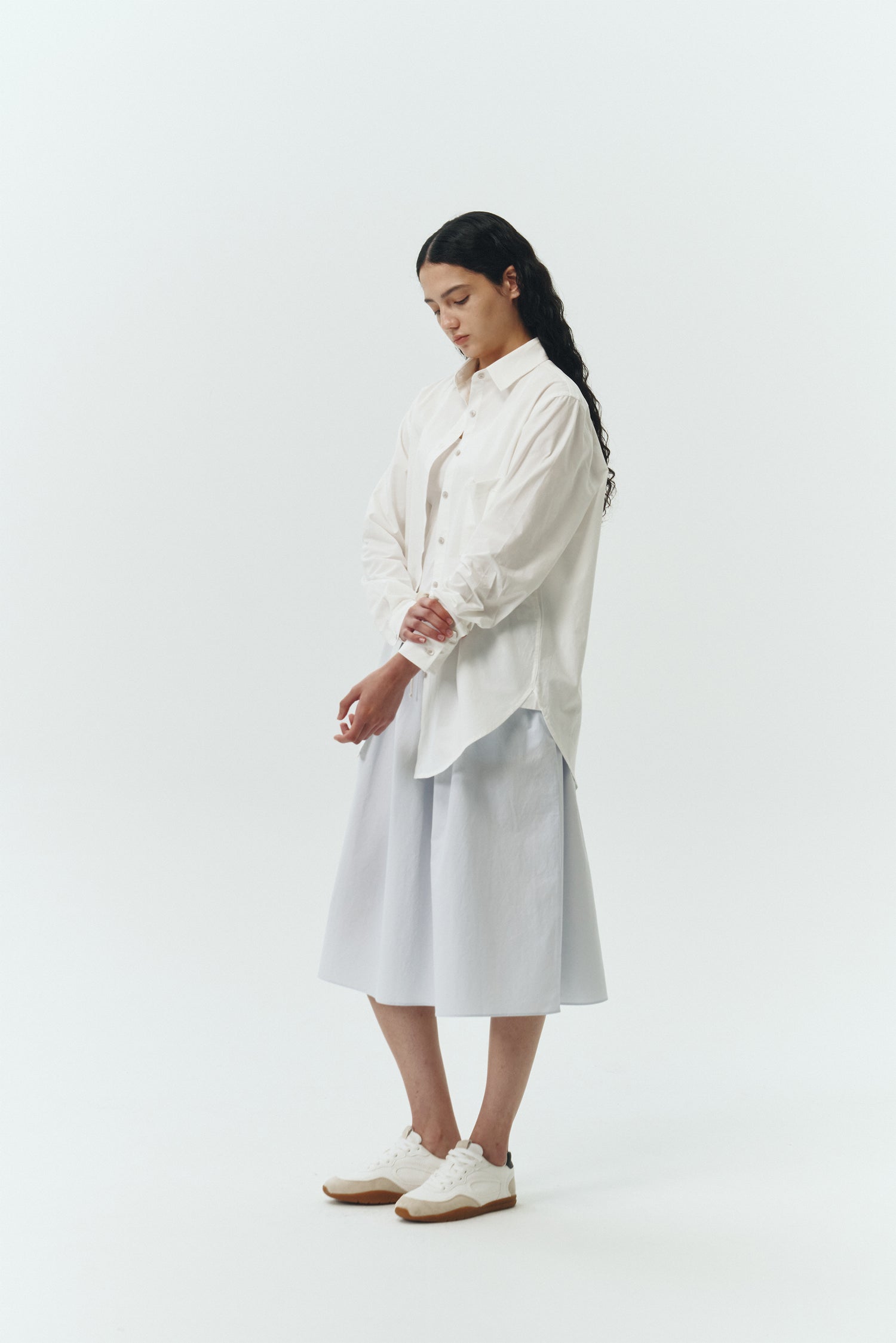 Isabella Shirt in white, a lightweight cotton-poly blend button-up with chest pocket, back pleat, and buttoned cuffs, designed in a regular fit with a hip-length silhouette