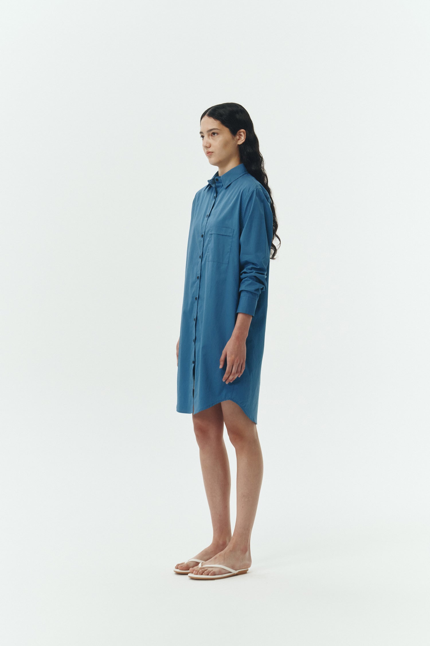 Cara Dress in blue green, long sleeve cotton shirt dress with front chest pocket, curved hem, hidden side pockets, and a relaxed silhouette.
