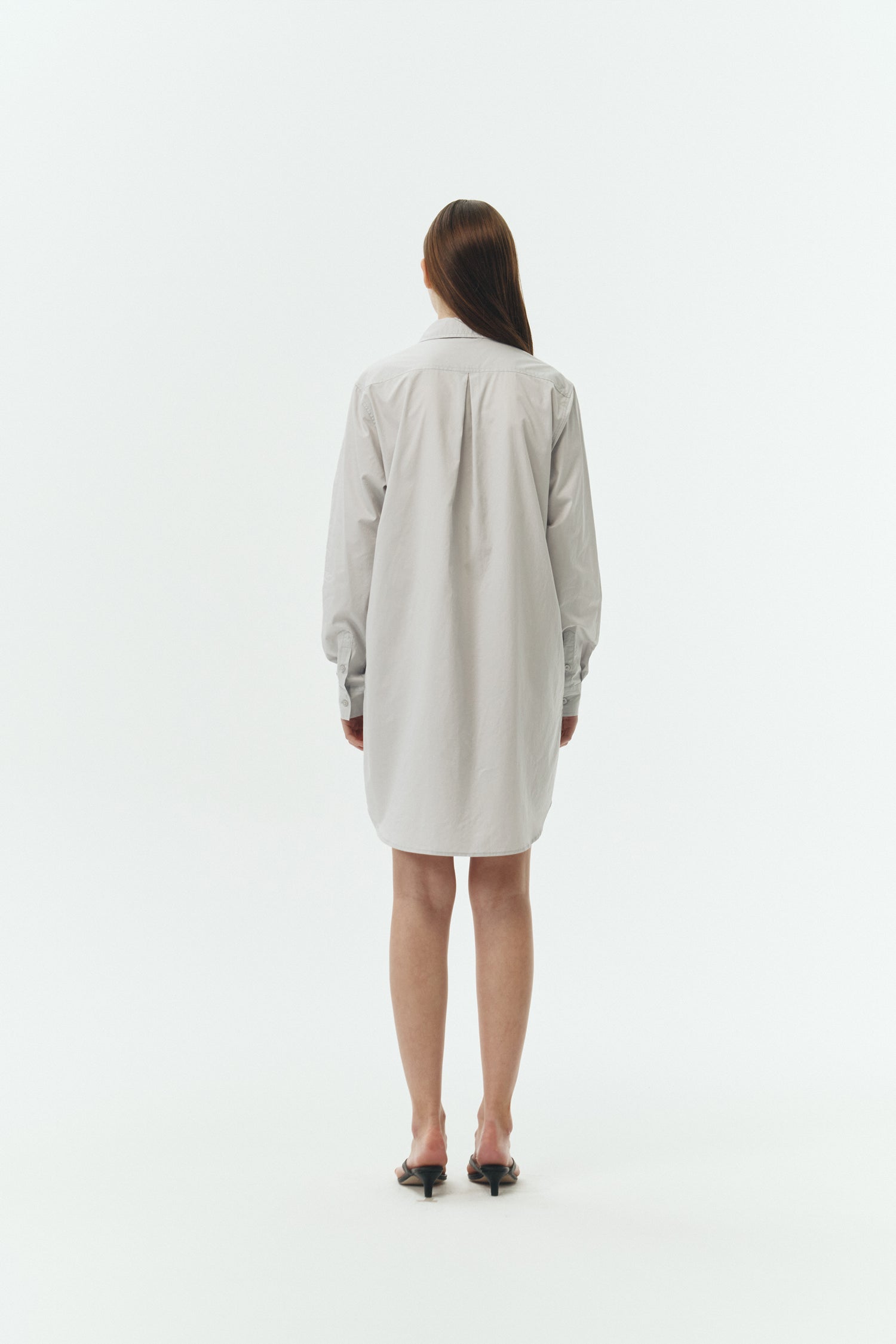 Cara Dress in cloud gray, long sleeve cotton shirt dress with front chest pocket, curved hem, hidden side pockets, and a relaxed silhouette.