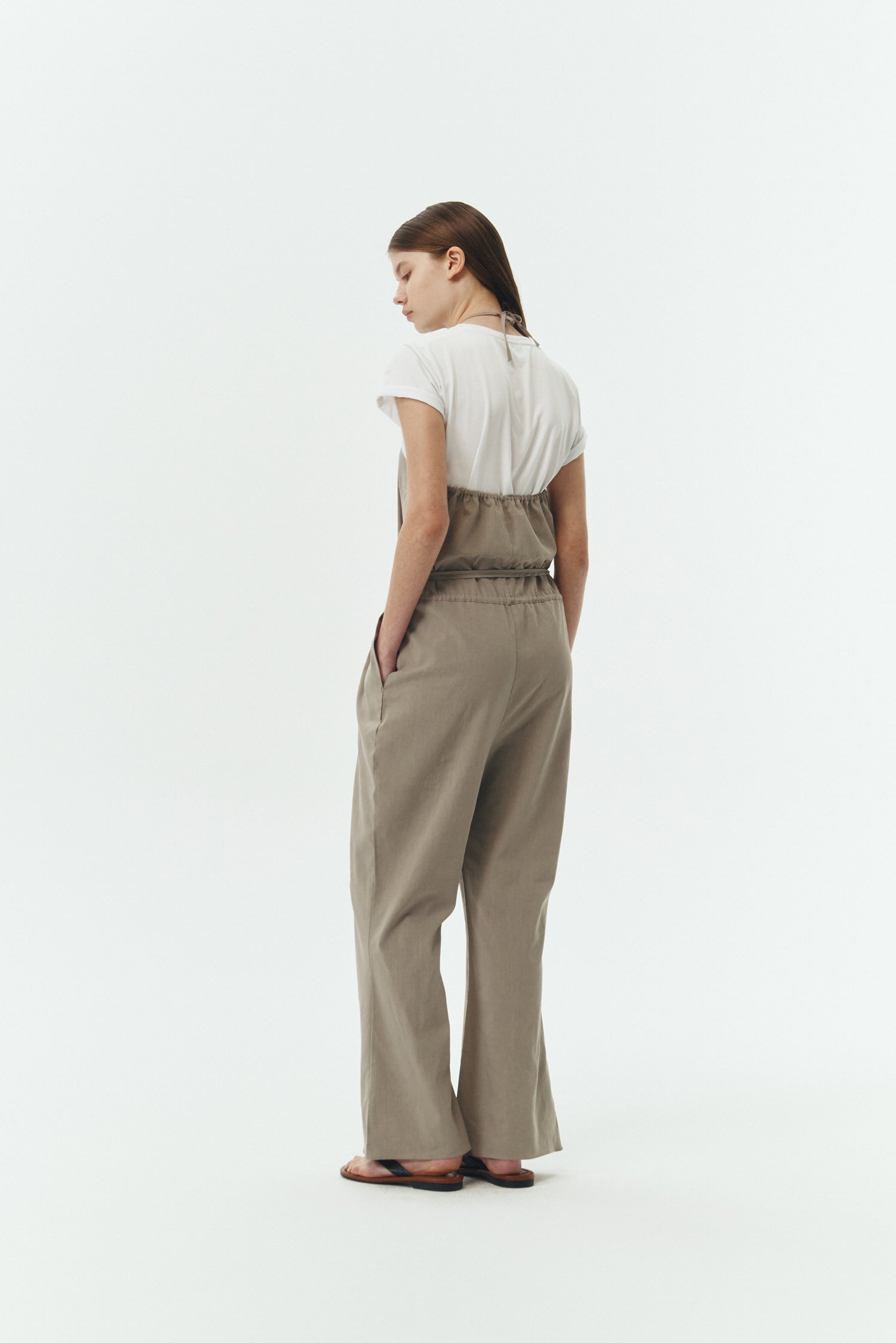 Daisy Jumpsuit in khaki gray, sleeveless linen blend jumpsuit with adjustable halterneck, open back, straight-leg silhouette, and relaxed fit.