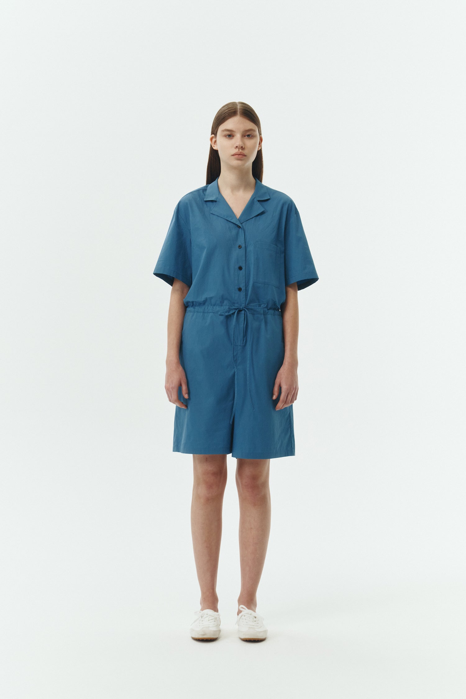 Emma Jumpsuit in blue green, short-sleeve cotton jumpsuit with camp collar, front buttons, drawstring waist, and multiple pockets.