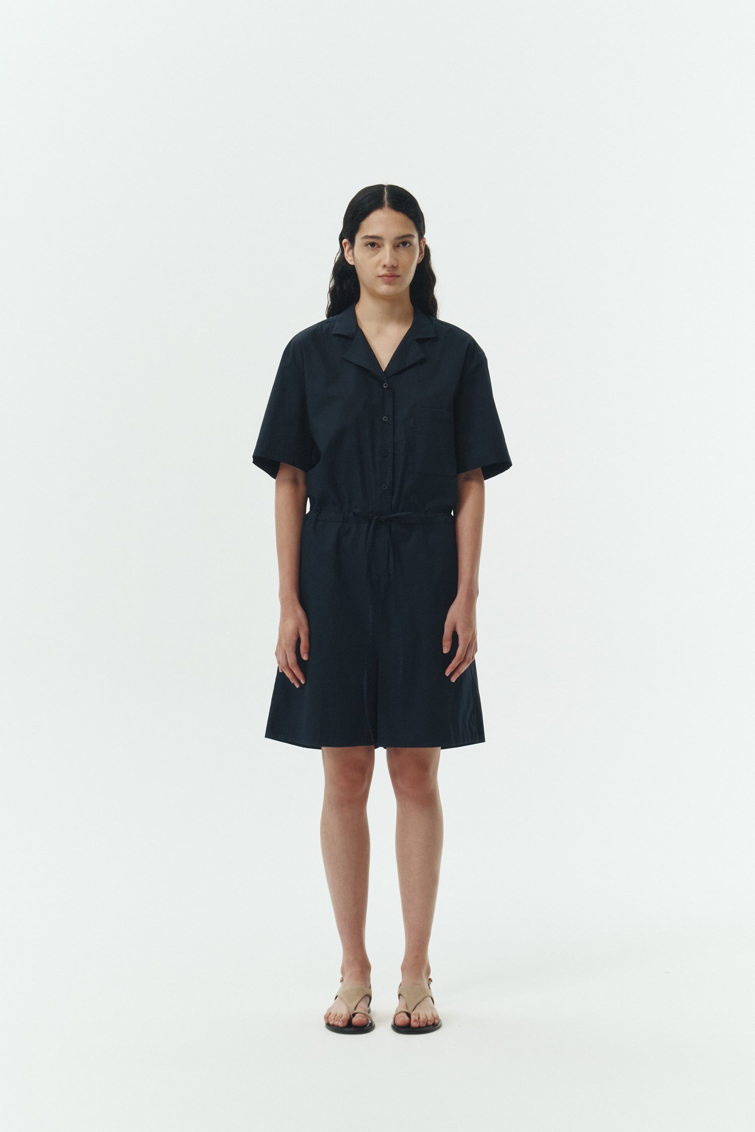 Emma Jumpsuit in navy, short-sleeve cotton jumpsuit with camp collar, front buttons, drawstring waist, and multiple pockets.