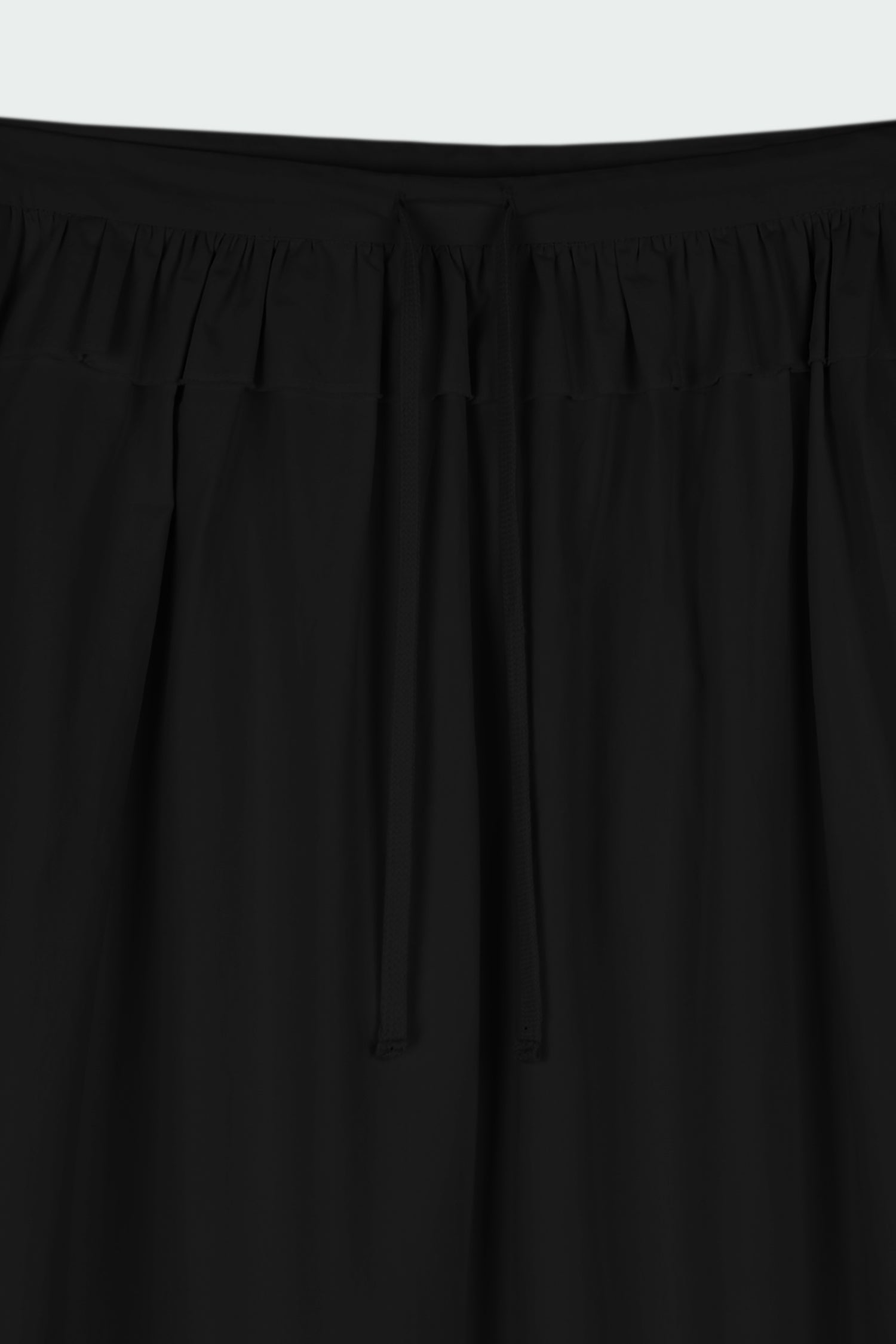 Maryam Skirt in black, a midi cotton skirt with shirred waistband, drawstring detail, side pockets, and a softly flared silhouette