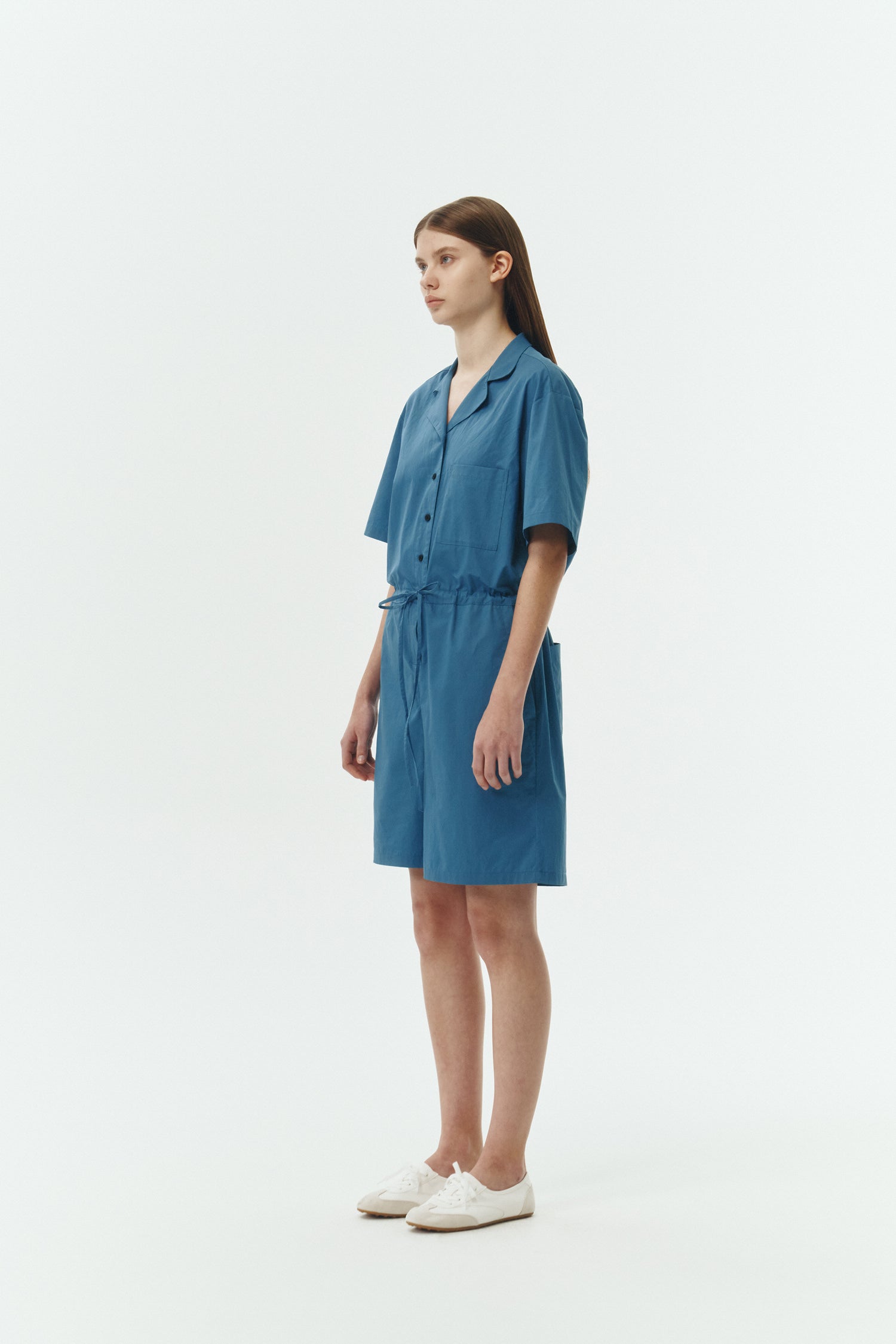 Emma Jumpsuit in blue green, short-sleeve cotton jumpsuit with camp collar, front buttons, drawstring waist, and multiple pockets.