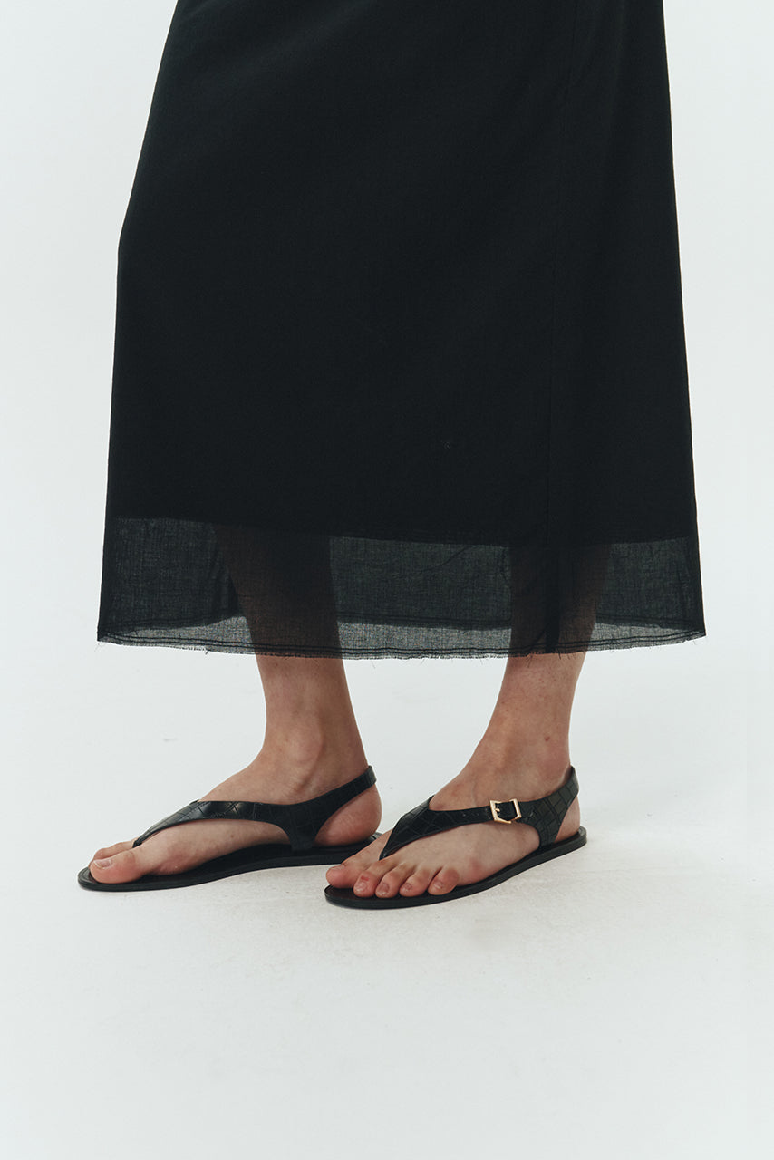Amelia Skirt in black, a lightweight cotton midi skirt with inner drawstring waist, hidden side pockets, lined layers, raw-edge hem, and a center back slit for ease and movement