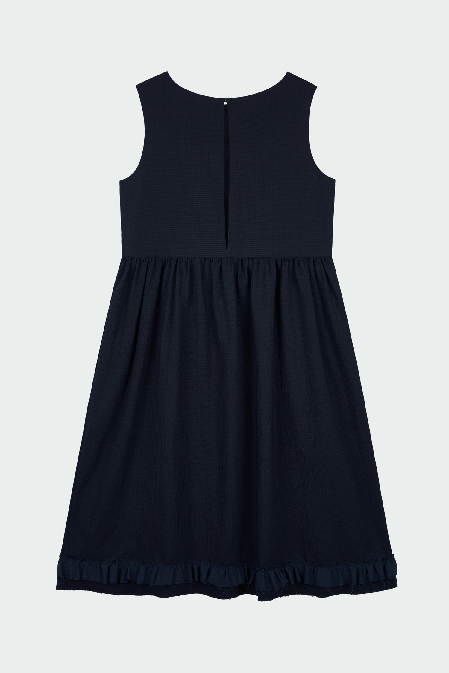 Pina Dress in navy, sleeveless cotton midi dress with shirring at waist and hem, hidden side pockets, and an open back with button closure.