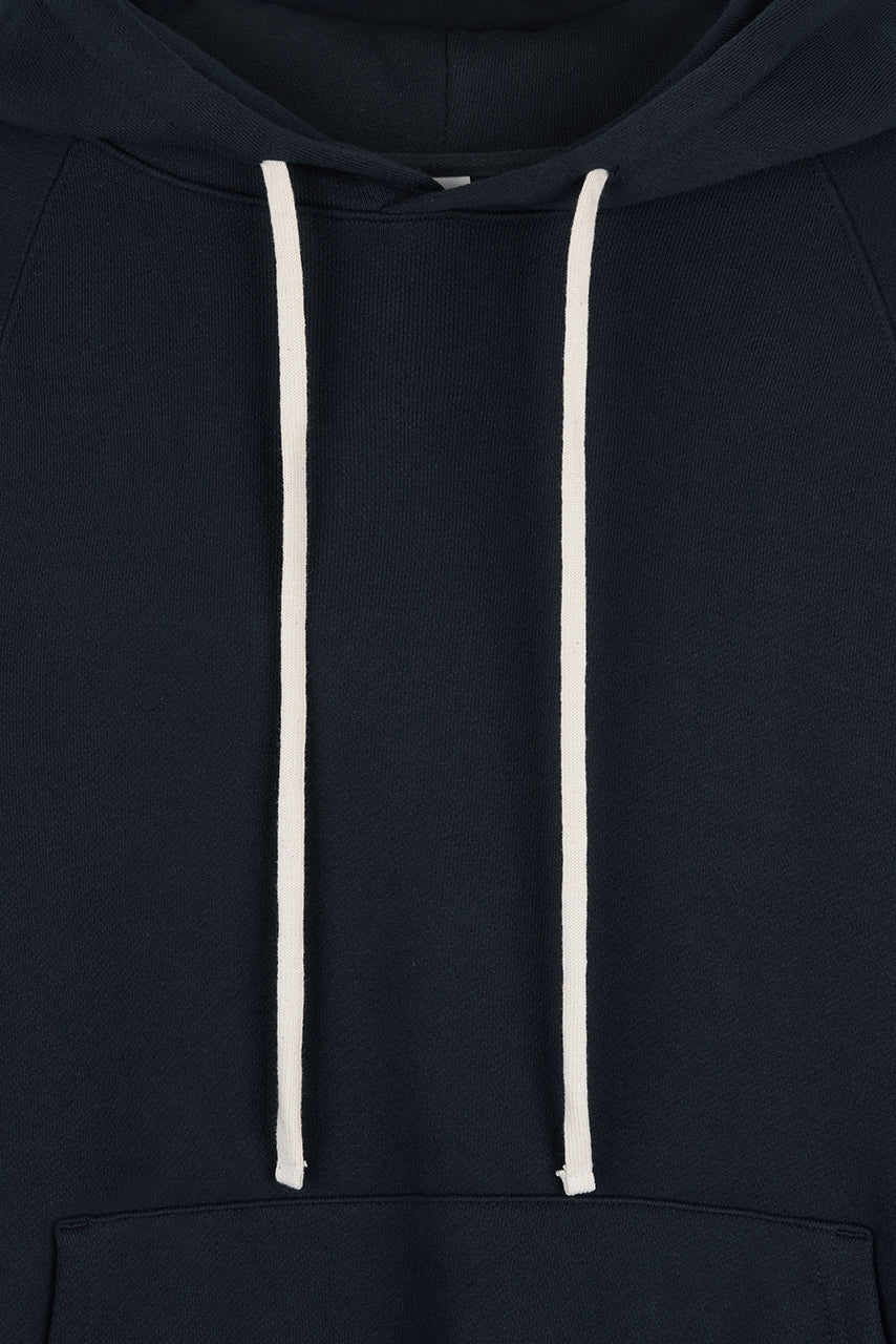 Kaia Hoodie in navy, oversized cotton French terry pullover with drawstring hood, raglan sleeves, kangaroo pocket, and ribbed trims.