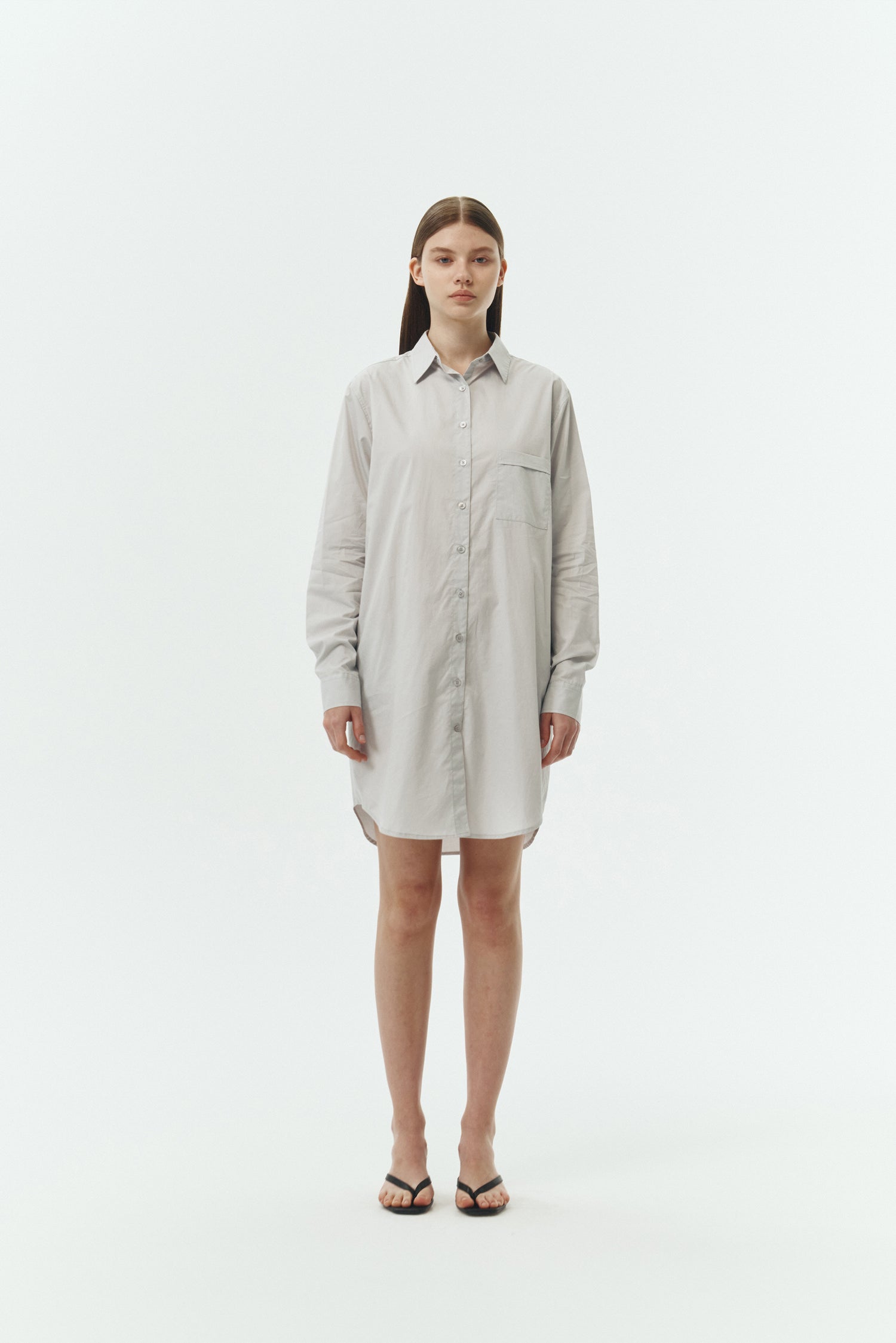 Cara Dress in cloud gray, long sleeve cotton shirt dress with front chest pocket, curved hem, hidden side pockets, and a relaxed silhouette.