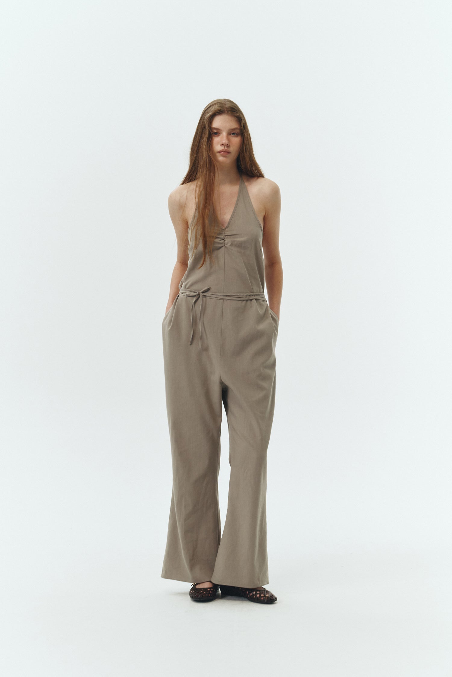 Daisy Jumpsuit in khaki gray, sleeveless linen blend jumpsuit with adjustable halterneck, open back, straight-leg silhouette, and relaxed fit.