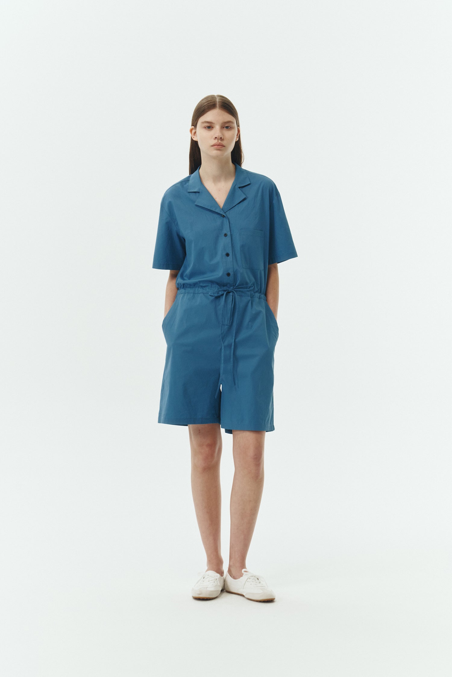Emma Jumpsuit in blue green, short-sleeve cotton jumpsuit with camp collar, front buttons, drawstring waist, and multiple pockets.