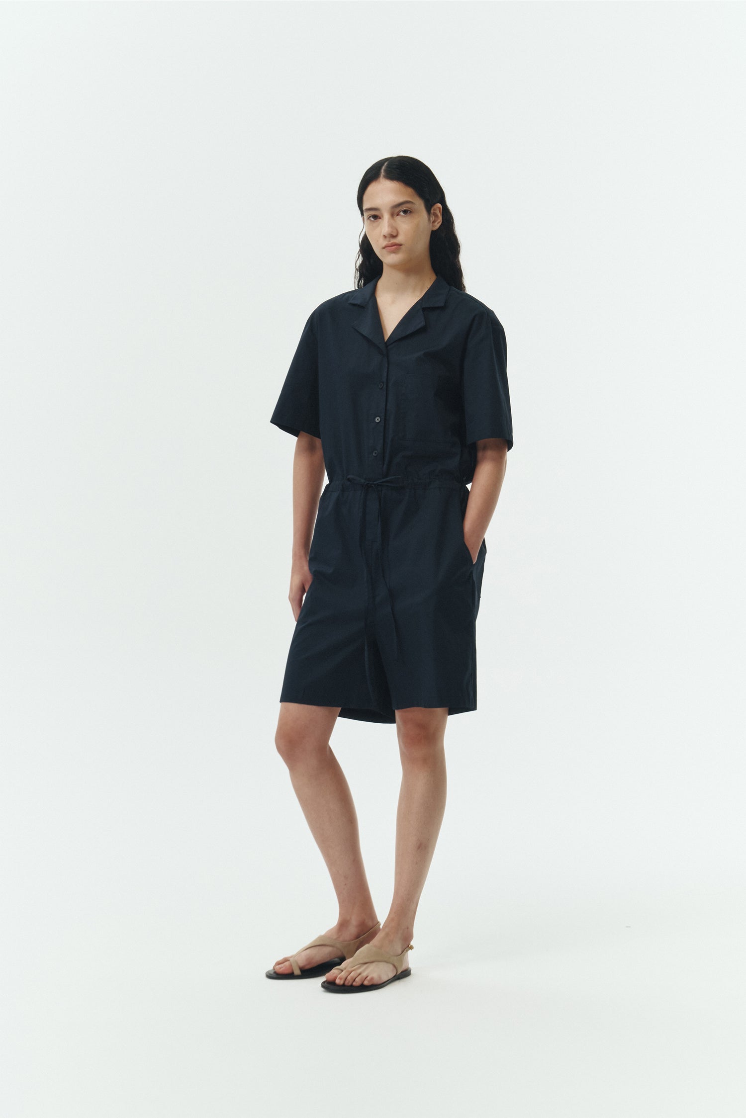 Emma Jumpsuit in navy, short-sleeve cotton jumpsuit with camp collar, front buttons, drawstring waist, and multiple pockets.