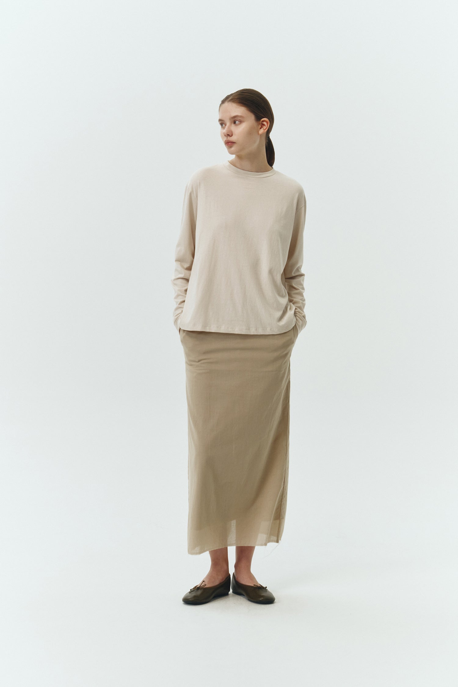Amelia Skirt in sand, a lightweight cotton midi skirt with inner drawstring waist, hidden side pockets, lined layers, raw-edge hem, and a center back slit for ease and movement