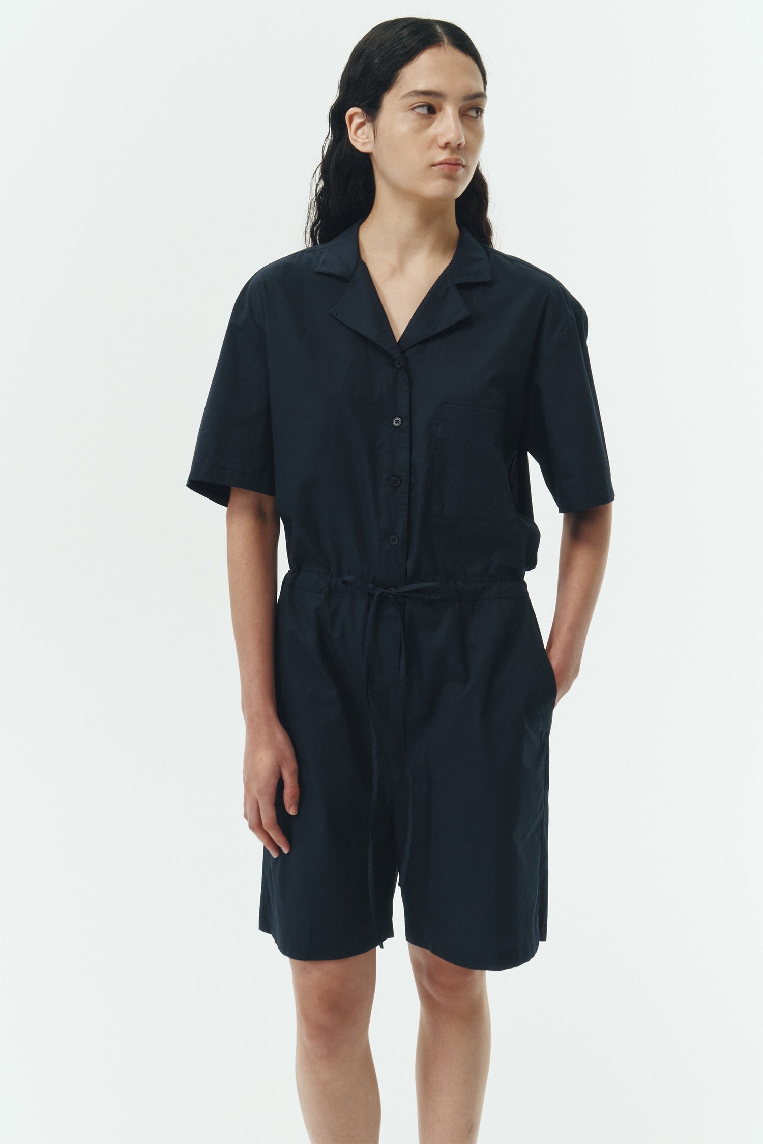 Emma Jumpsuit in navy, short-sleeve cotton jumpsuit with camp collar, front buttons, drawstring waist, and multiple pockets.