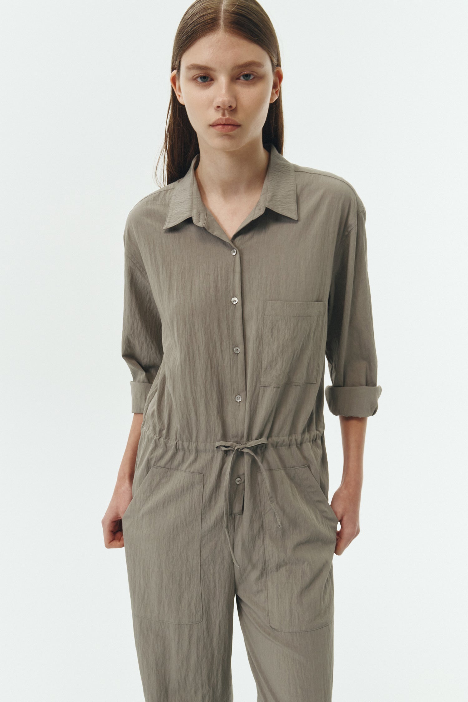 Saige Jumpsuit in khaki gray, long-sleeve rayon blend jumpsuit with point collar, front button closure, drawstring waist, and patch pockets.
