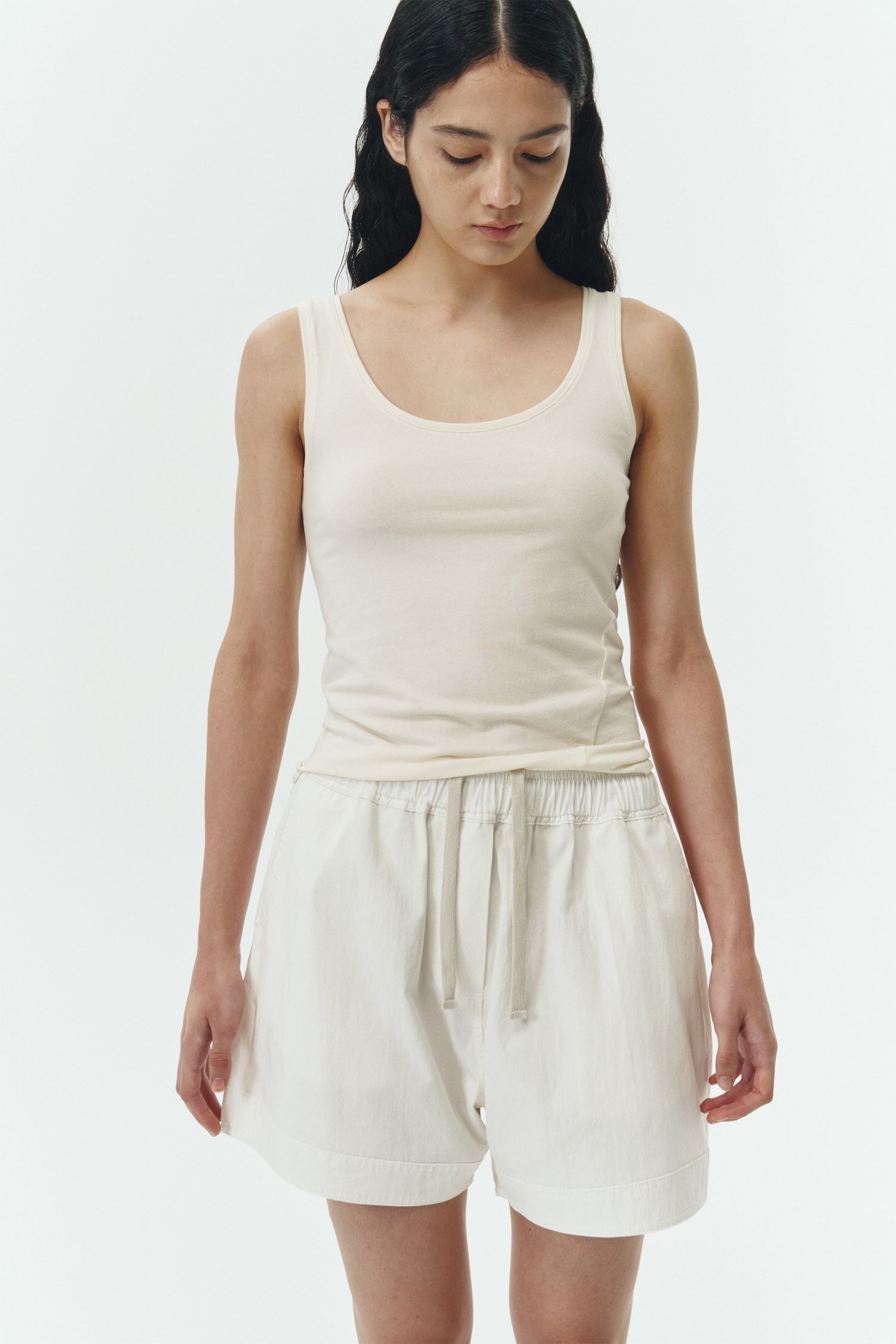 Zoe Tank Top in cream, slim-fit stretch cotton tank with scooped neckline and diagonal seam detail for a sleek and minimal silhouette.