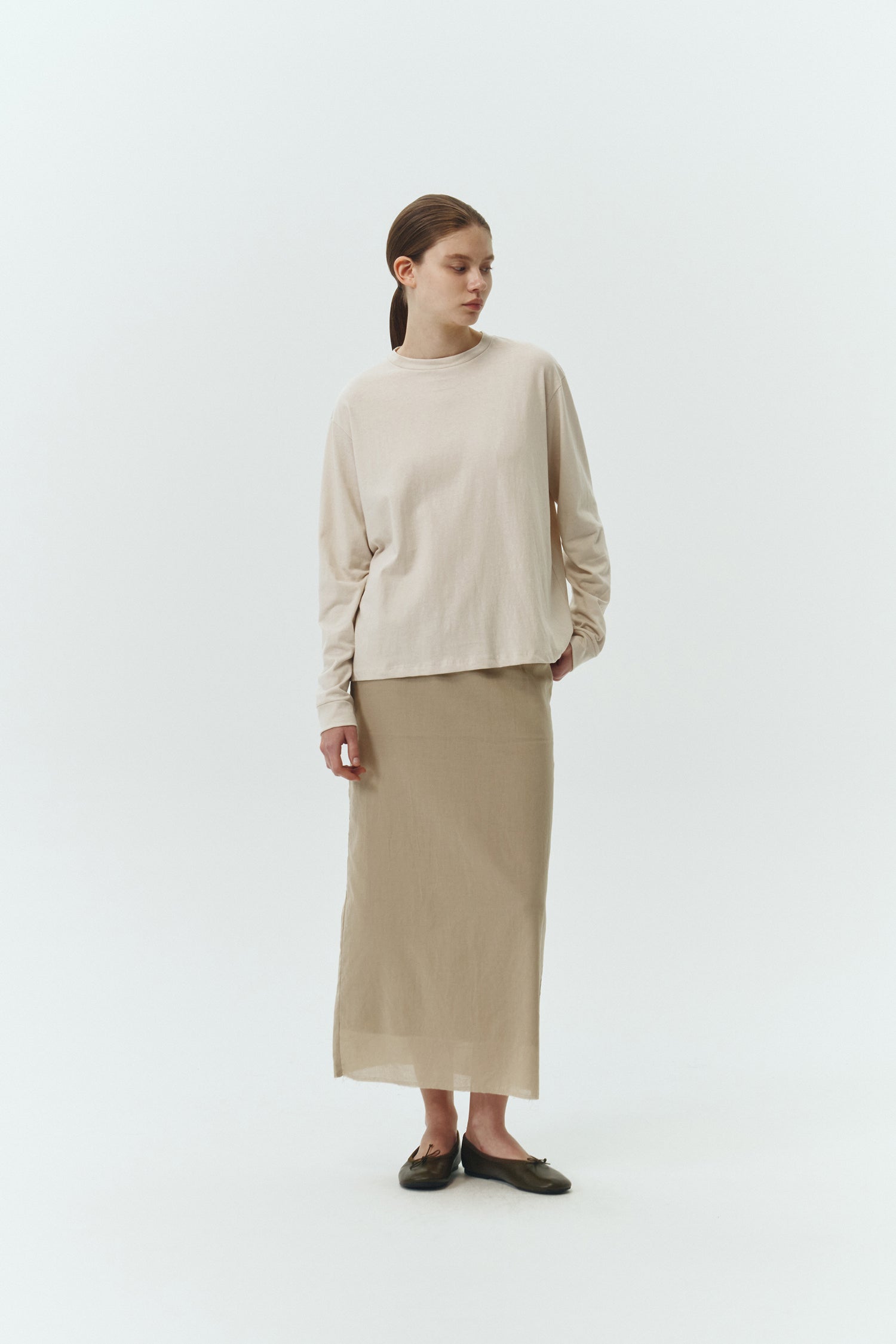 Amelia Skirt in sand, a lightweight cotton midi skirt with inner drawstring waist, hidden side pockets, lined layers, raw-edge hem, and a center back slit for ease and movement