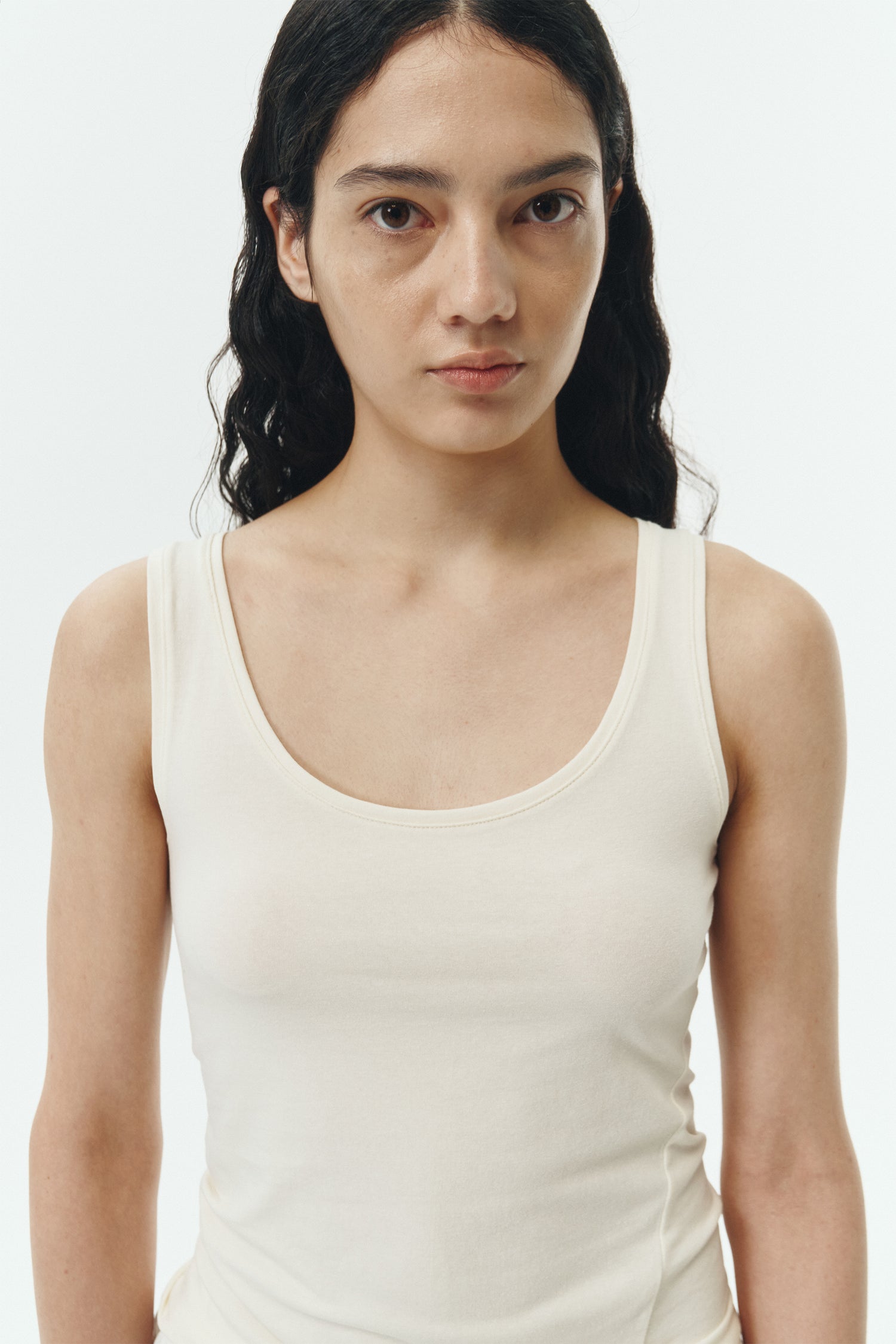 Zoe Tank Top in cream, slim-fit stretch cotton tank with scooped neckline and diagonal seam detail for a sleek and minimal silhouette.