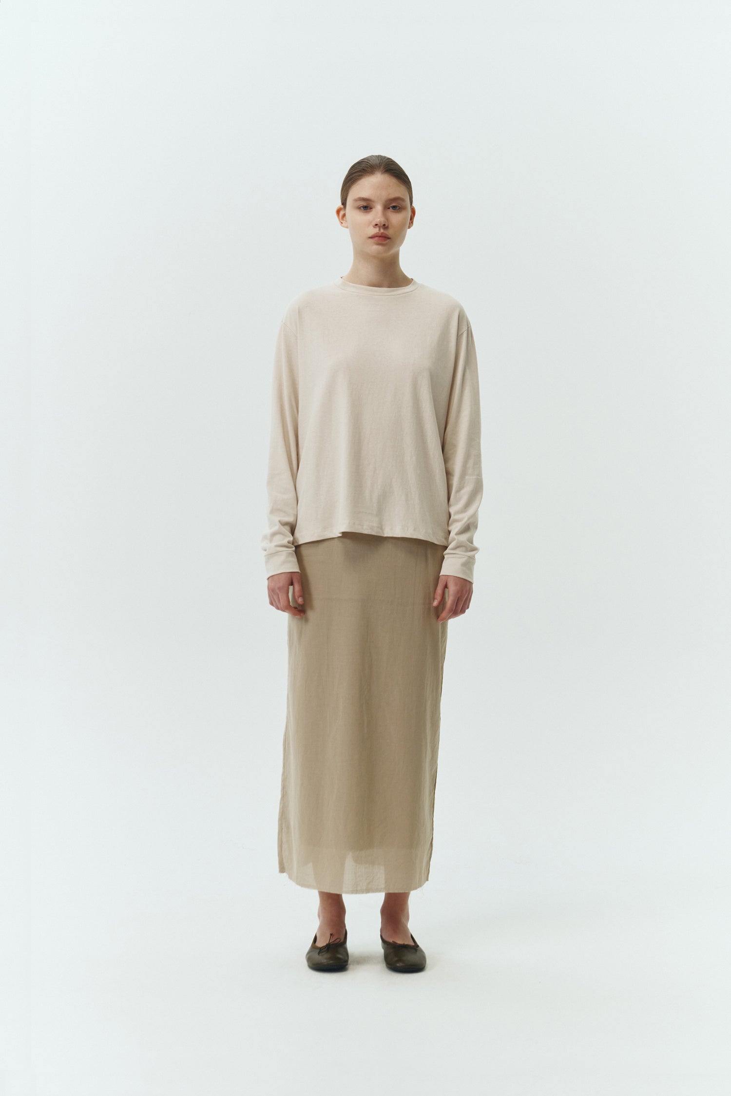 Amelia Skirt in sand, a lightweight cotton midi skirt with inner drawstring waist, hidden side pockets, lined layers, raw-edge hem, and a center back slit for ease and movement